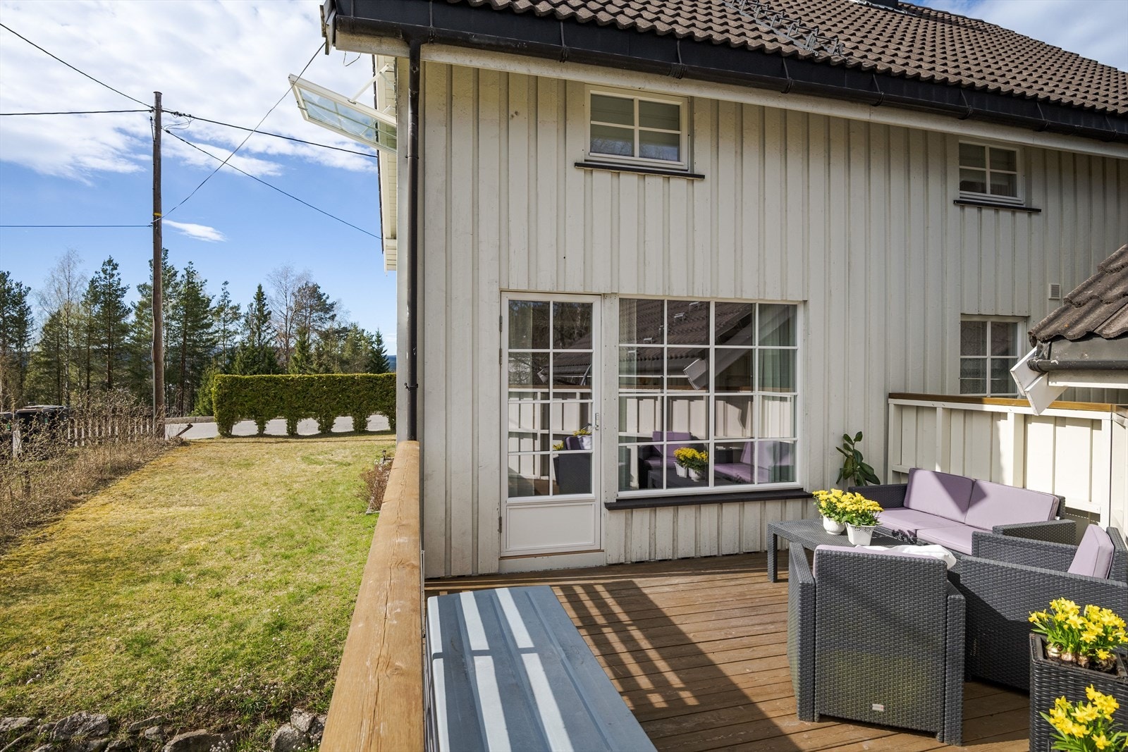 Terrassen har terrassebord på gulv, rekkverk og tette vegger mot hovedterrassen. Galleribilde
