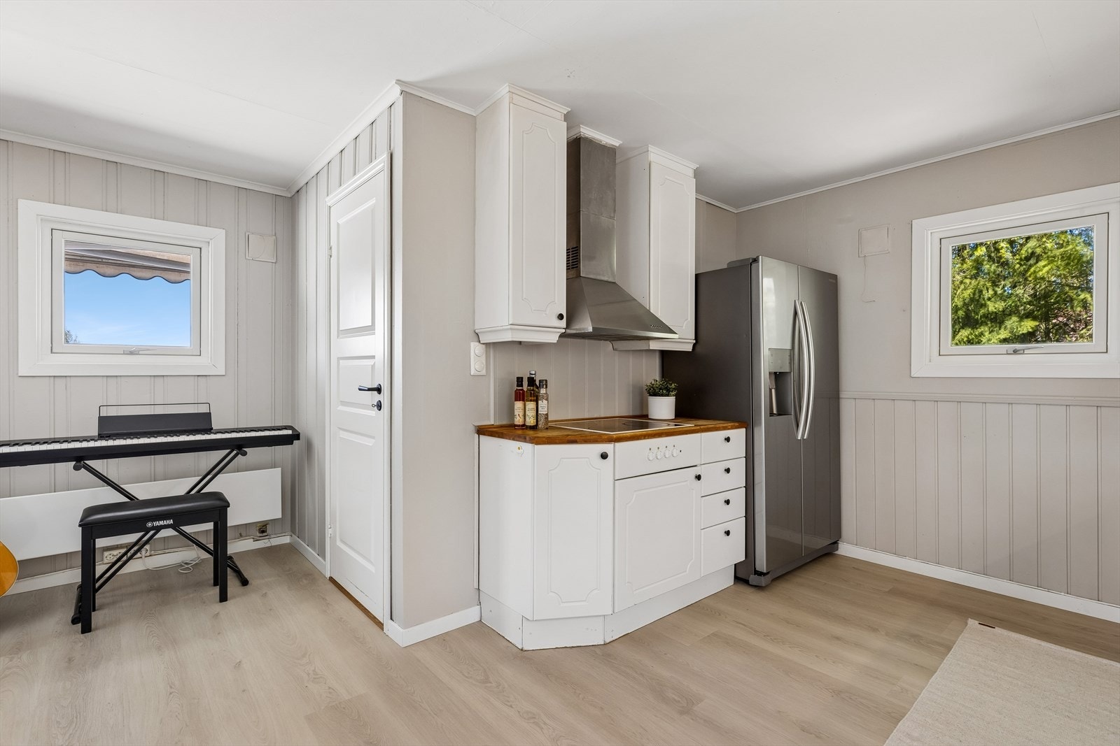 Kjøkkenet er praktisk utformet som en del av den åpne stueløsningen. Om man ønsker en hjemmekontorplass kan man ha dette der pianoet står. Galleribilde