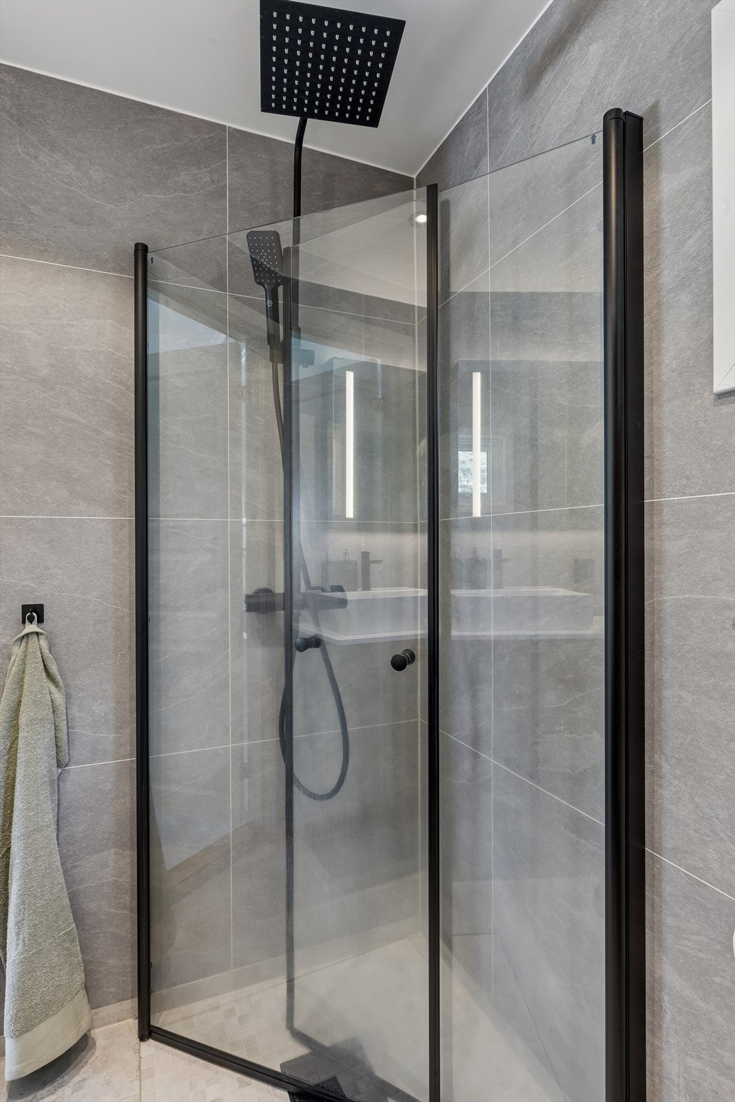 Dusjhjørne med innfellbare glassvegger, montert direkte på gulvet. Badet ble pusset opp av fagfolk i 2023. Galleribilde