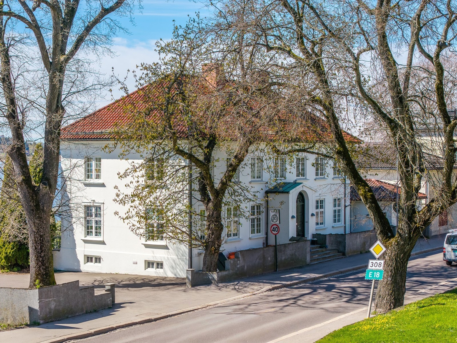 Eiendommen ligger markant til i landskapet, med pussede murfasader og glassert takstein. Galleribilde