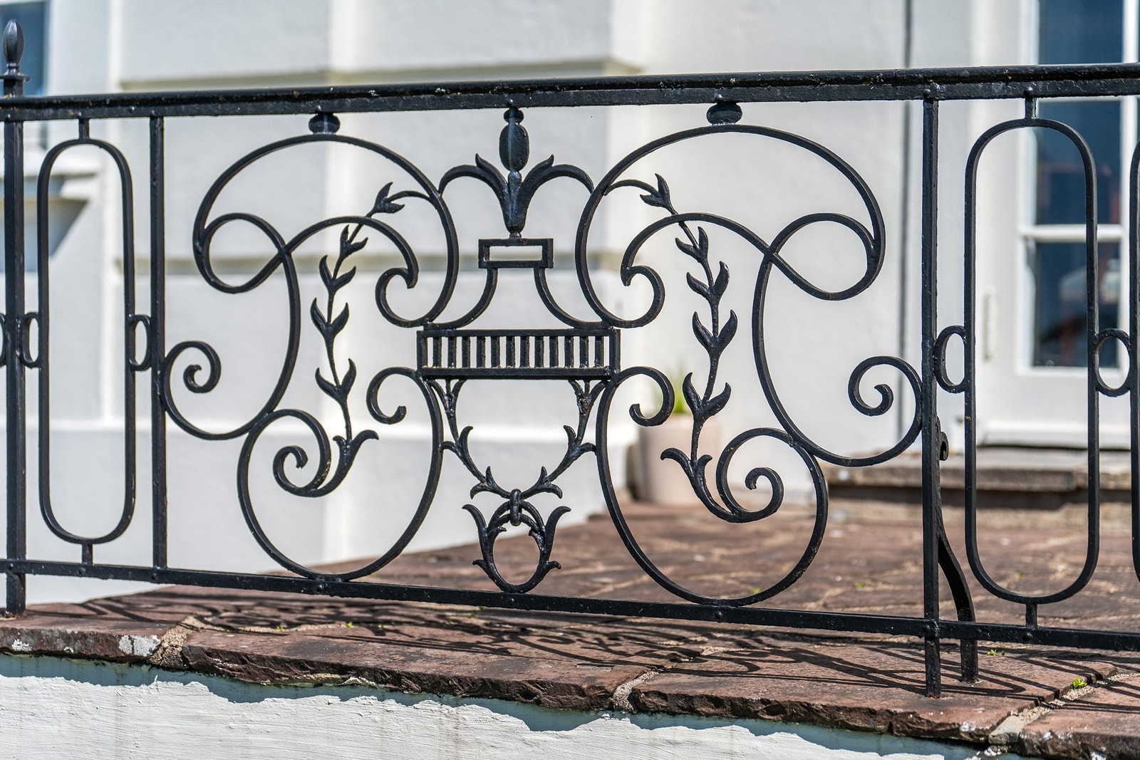 På den elegante terrassen som går langs hele langsiden av boligen er det et rekkverk i smijern og den deles av et bredt trappeløp ned til hagen. Galleribilde