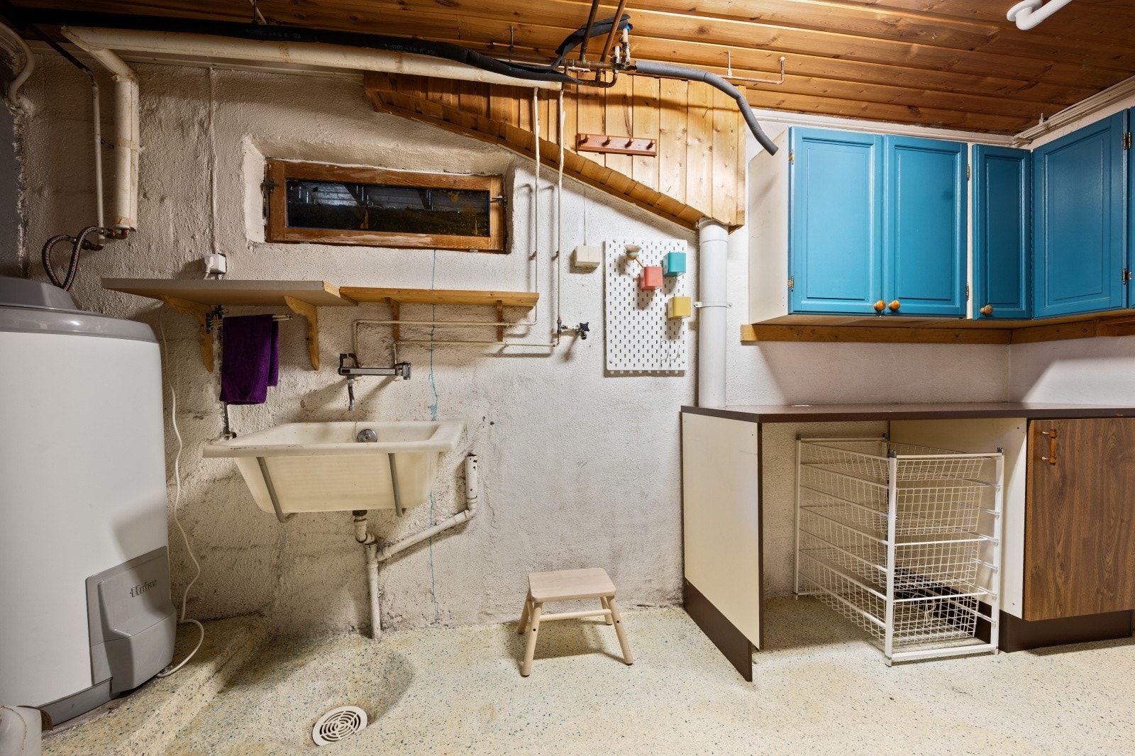 Vaskerom i kjelleren med utslagsvask, opplegg for vaskemaskin og en varmtvannstank på ca. 200 liter. Galleribilde