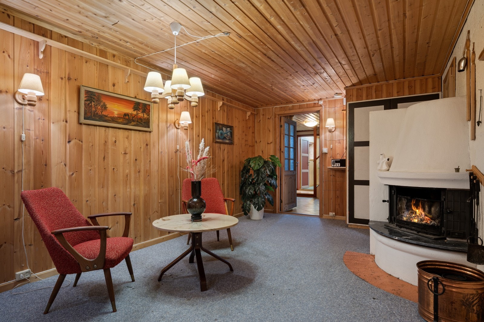 Peisestuen har panel på vegger og tak, og teppe på gulvet. Rommet er i dag innredet som et sosialt samlingssted og har peis med innsats. Galleribilde