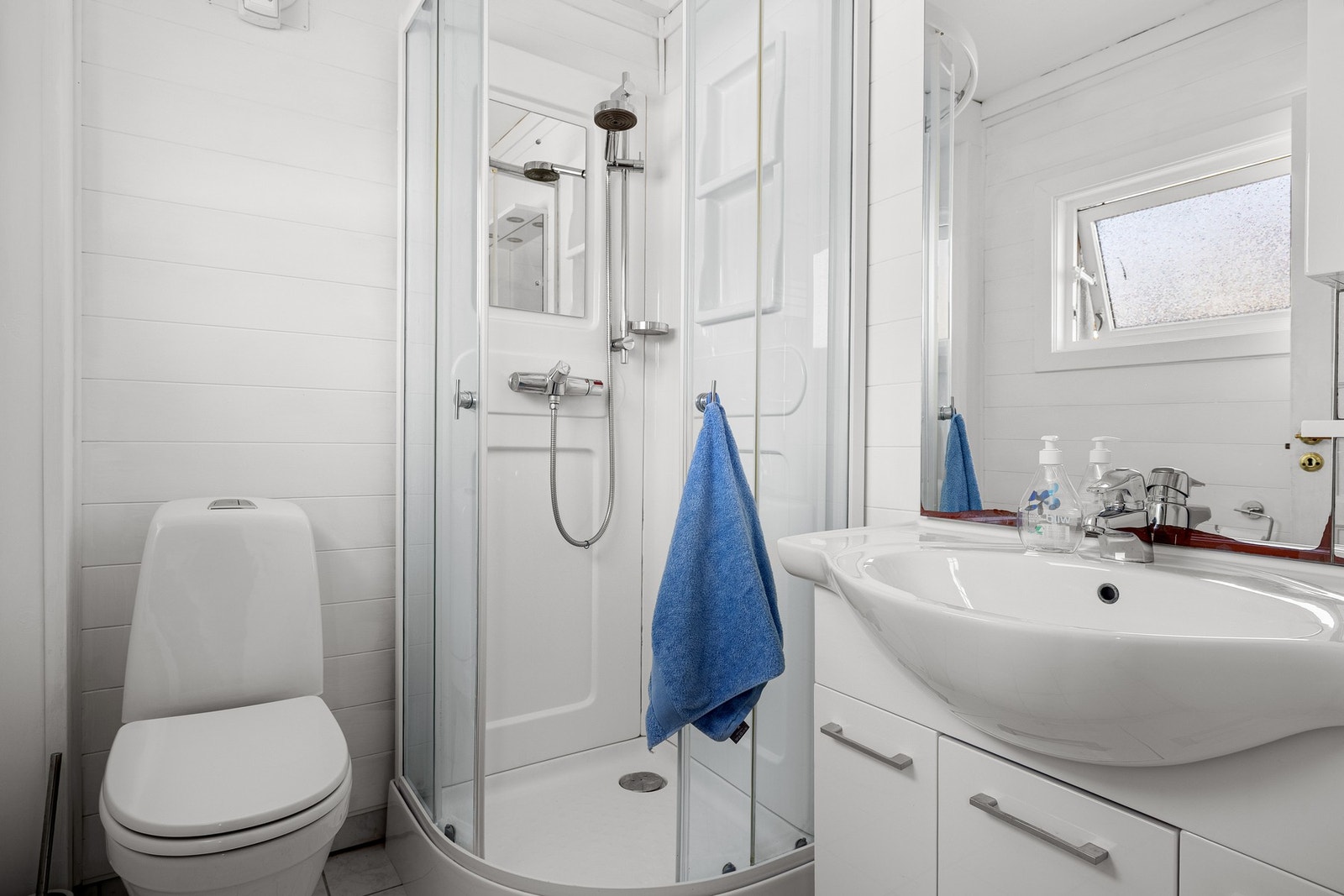 Badet måles til 2,7 kvm. og er fliselagt på gulv og kledd med MDF-panel på vegger. Galleribilde