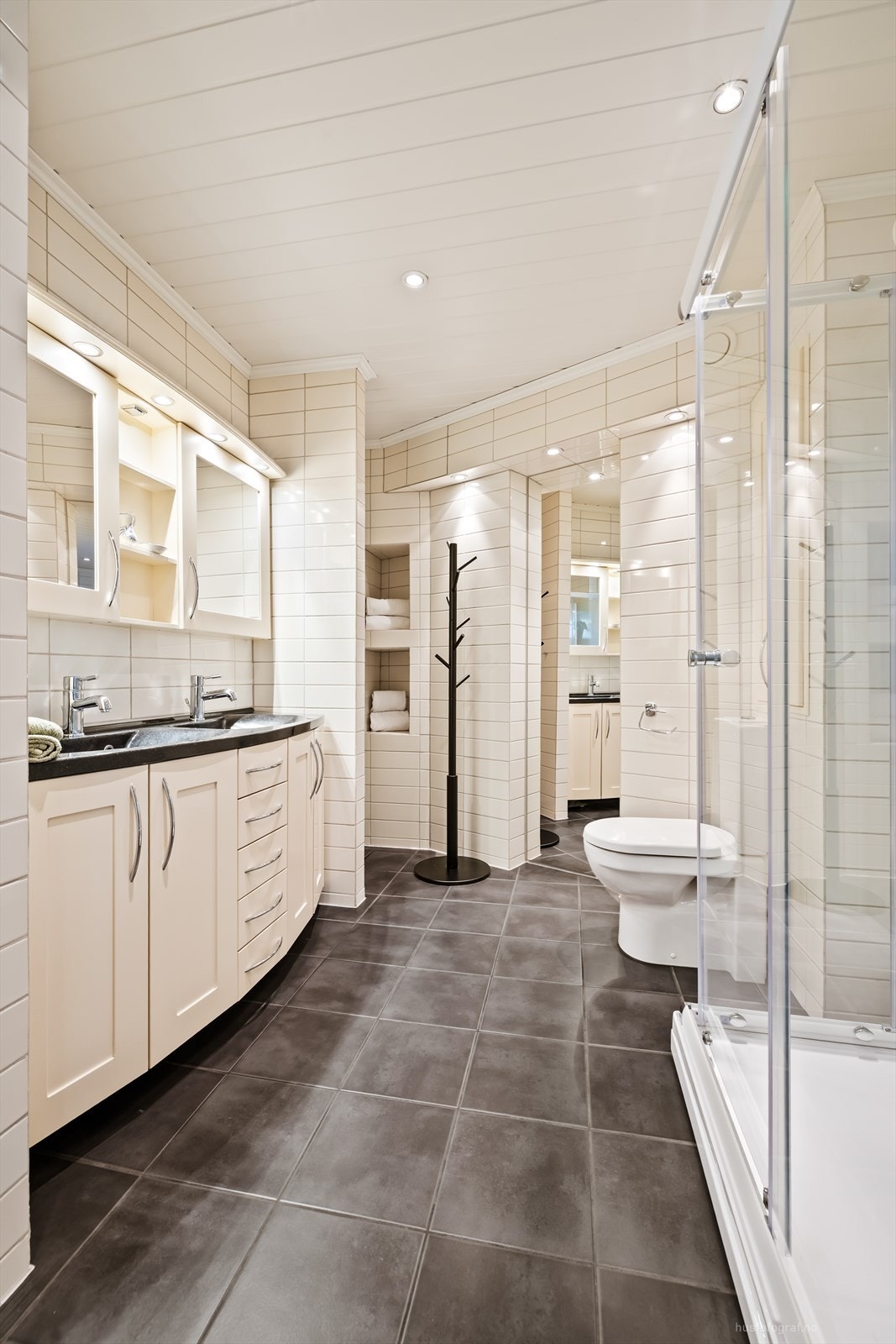 Badet er utstyrt med dusjkabinett, toalett og downlights i taket. Galleribilde