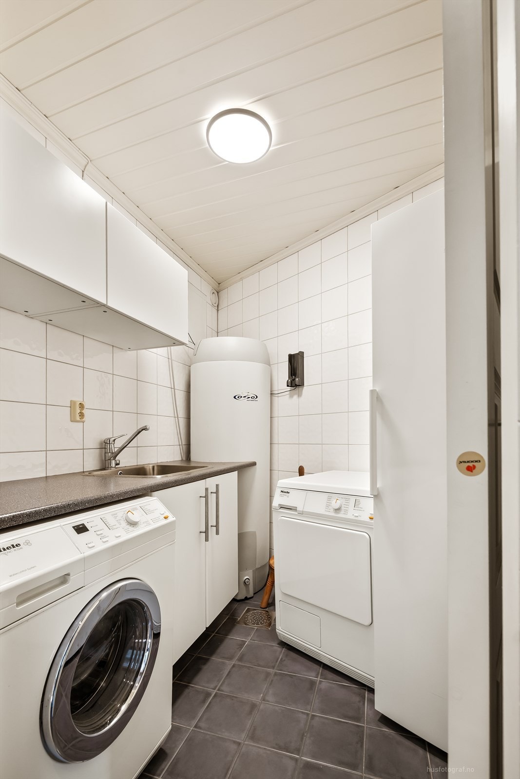 Separat vaskerom med flislagt gulv med elektriske varmekabler og opplegg for vaskemaskin. Galleribilde