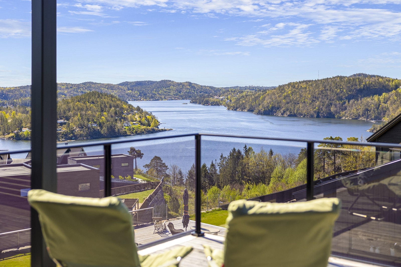 Det er en magisk utsikt til Tvedestrandsfjorden fra flere steder på eiendommen. Glassrekkverk som rammer inn utsikten. Galleribilde