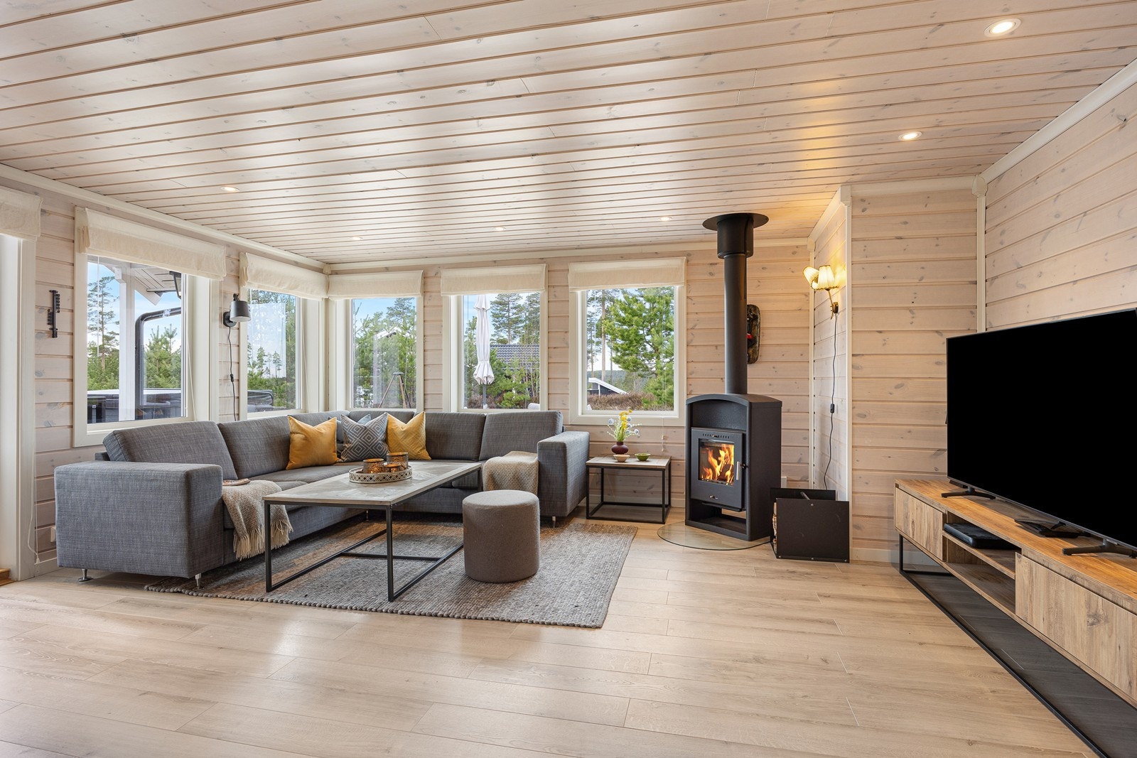 Dagslyset i stuen suppleres ypperlig av downlights, og et lyst 1-stavs laminatgulv kombineres med lyse trepaneler både i taket og på veggene. Galleribilde