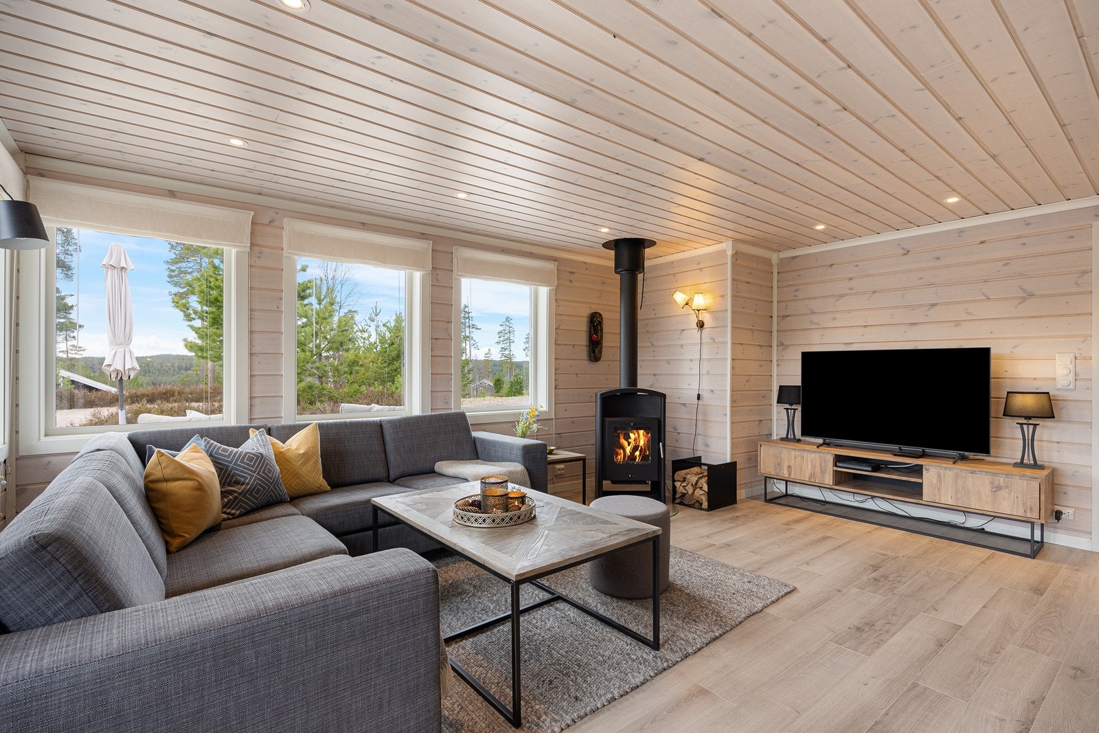 Utformingen gjør stuen enkel å møblere, og rommet er naturlig inndelt i ulike soner. Store vindusflater slipper inn godt med naturlig lys i hytta. Galleribilde