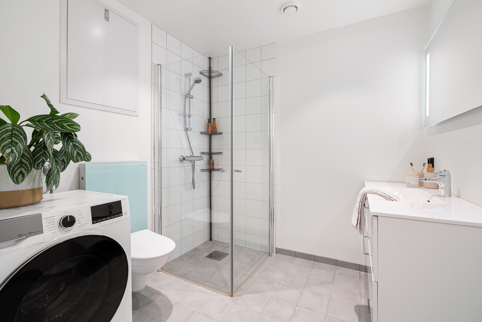 Badet er tidløst innredet med grå fliser på gulvet og en kombinasjon av hvite fliser i dusjsonen og ellers malte plater. I gulvet har man også vannbåren varme for ekstra komfort. Galleribilde
