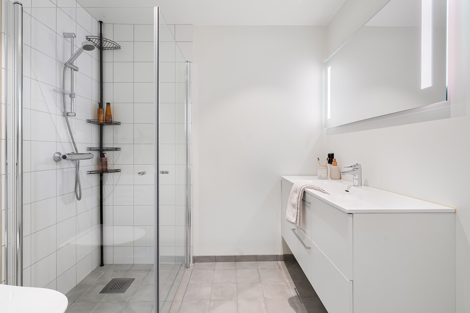 Badet er ellers utstyrt med dusjhjørne, vegghengt toalett og baderomsinnredning med god lagringsplass og nedfelt servant. I tillegg har man opplegg for vaskemaskin. Galleribilde