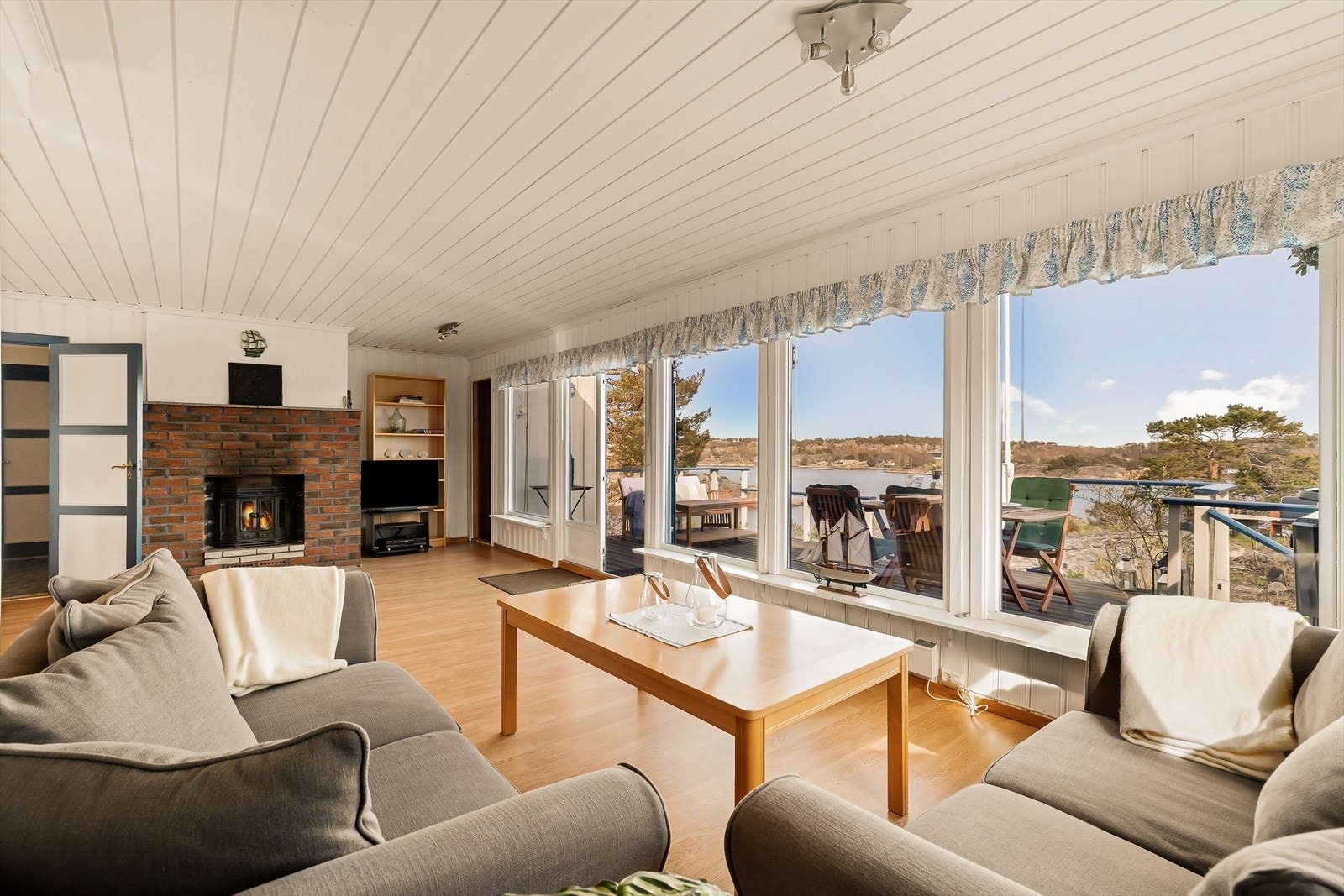 Stuen er romslig med plass til en stor sofagruppe. De brede vinduene slipper inn rikelig med lys og rammer inn utsikten mot sjøen. Galleribilde