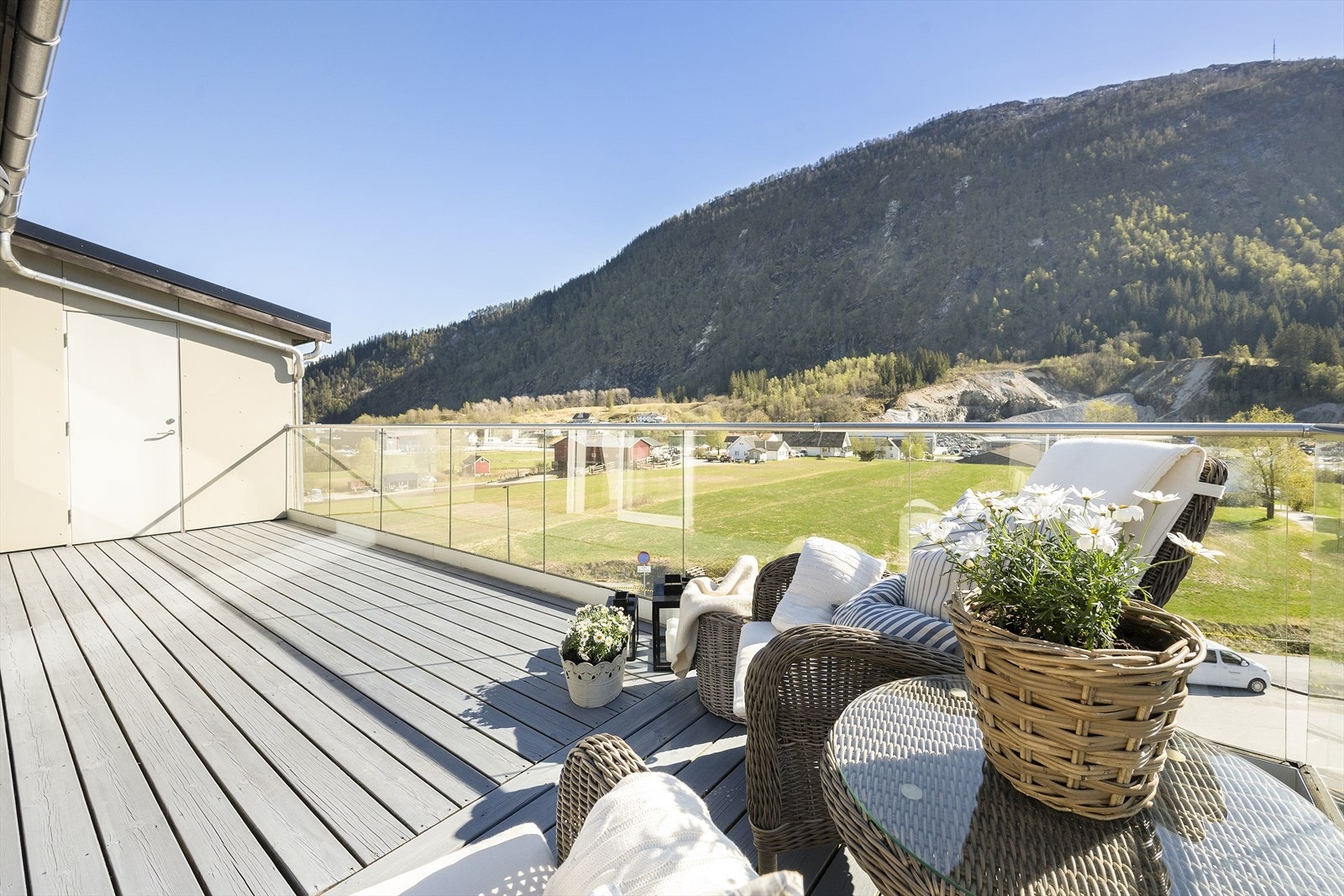 Verandaen har beisa terrassebord og rekkverk i glas og aluminium. Galleribilde