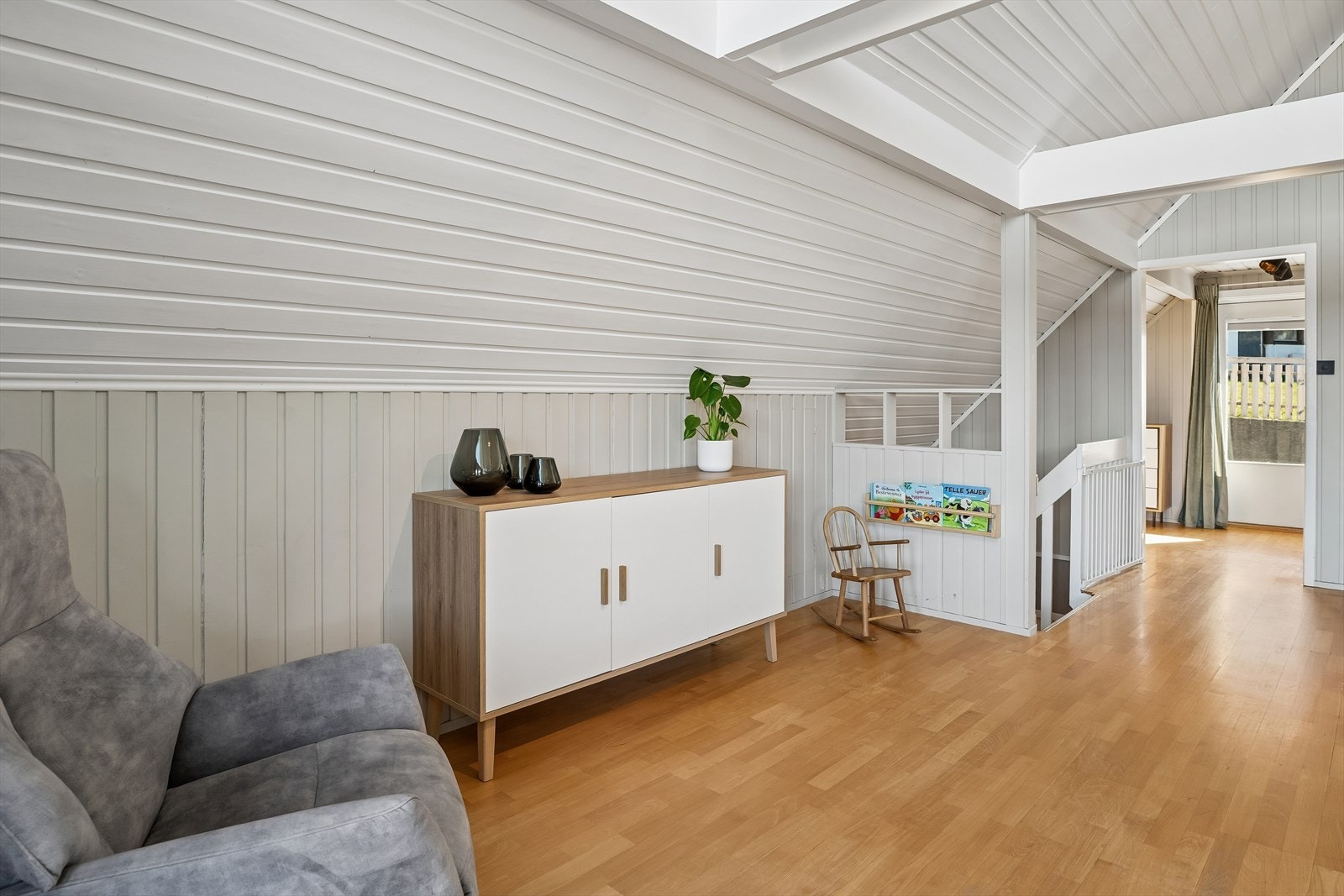 Velkommen til 1.etasje. Her kjem du opp i ei stove med mønehøgt tak, store vindaugsflater som slepp inn den nydelige utsikta! Galleribilde
