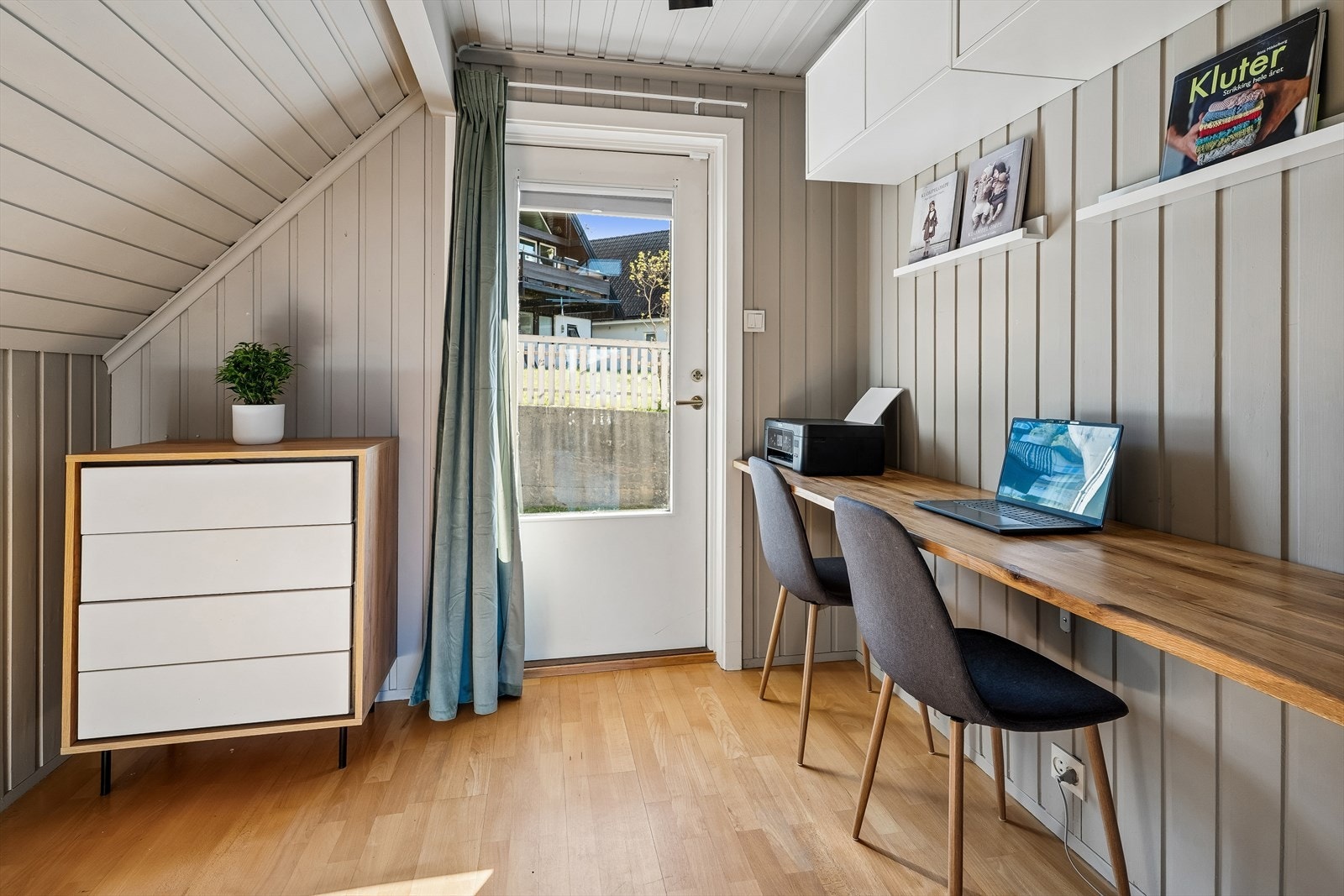 Inngang har du også i 1.etasje. Her er det også ein mindre altan med overbygg ved inngangsdøra.
I dag er rommet i hovudsak nytta som kontor. Galleribilde