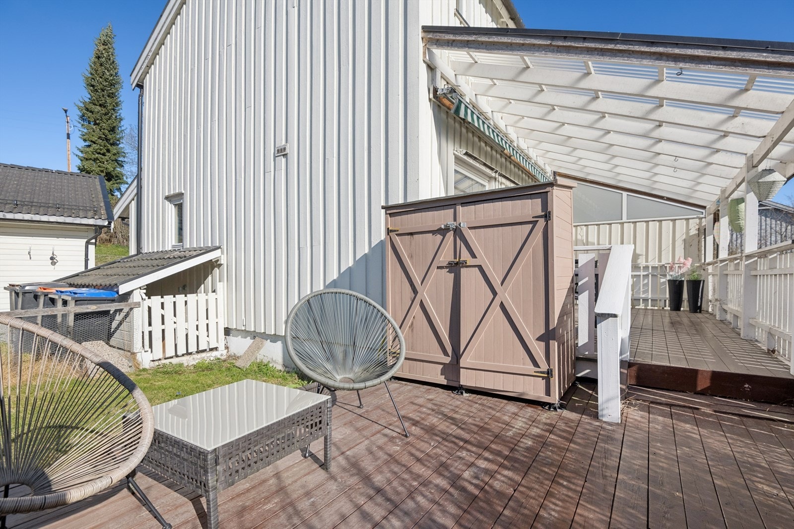 En liten bod med plass til hageredskaper er plassert i tilknytning til terrassen Galleribilde