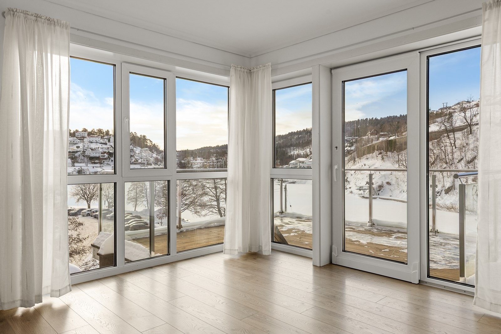 Stue med store vindusflater som gir godt naturlig lys i leiligheten Galleribilde