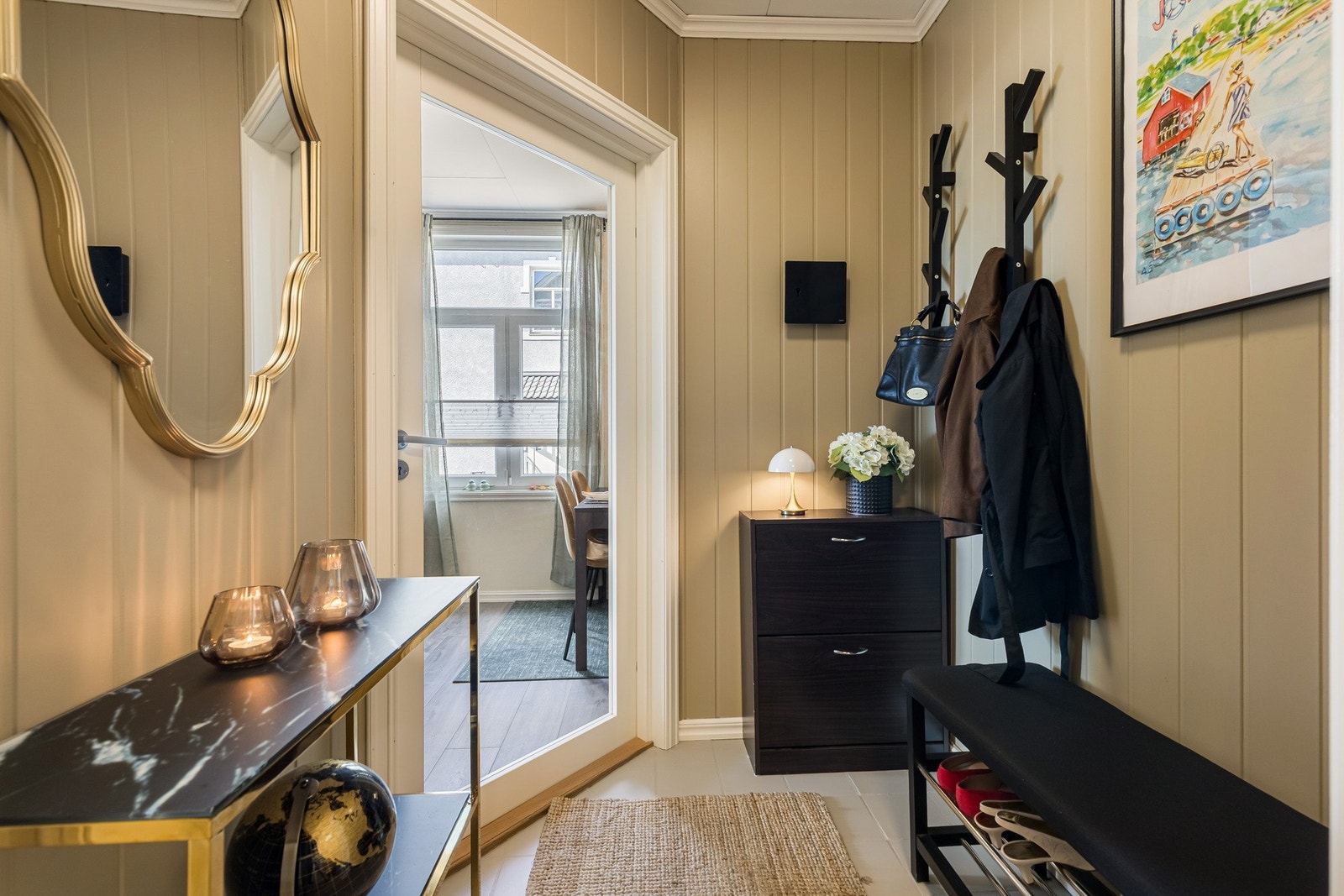 Man ønskes velkommen inn i en hyggelig entré med flislagt gulv og lyst malte vegger. Galleribilde