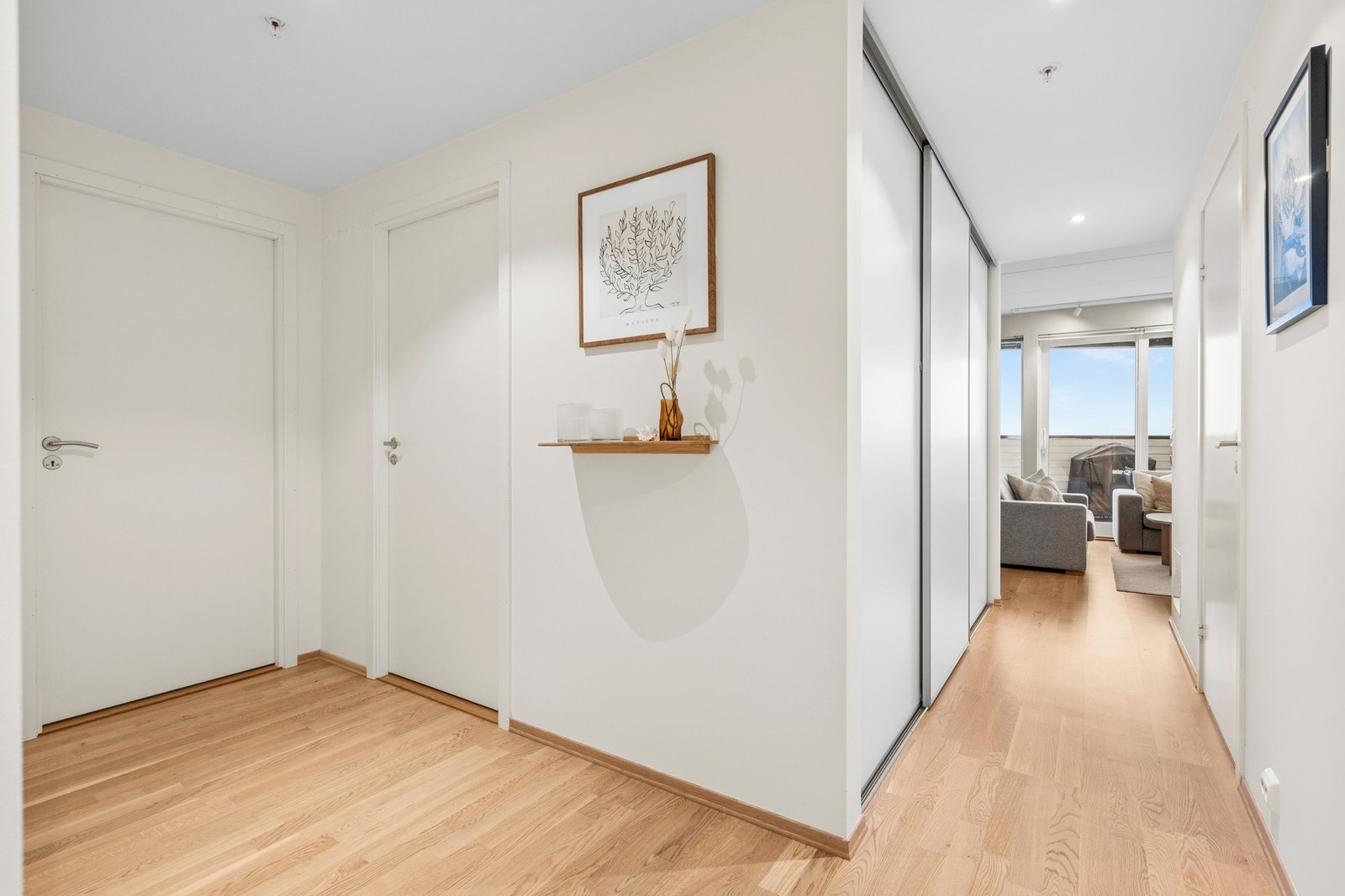 Velkommen inn! Lys og fin entré med stilren skyvedørsgarderobe som gir rikelig med oppbevaringsplass. Galleribilde