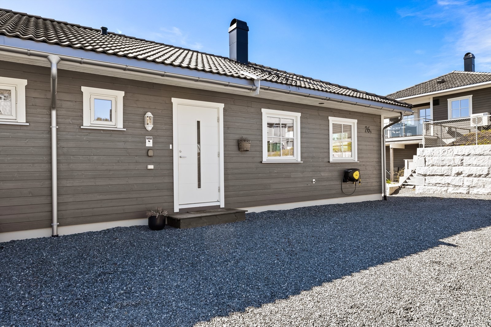 Eiendommen har en pen fasade med liggende bordkledning og tak tekket med betongtakstein. Galleribilde