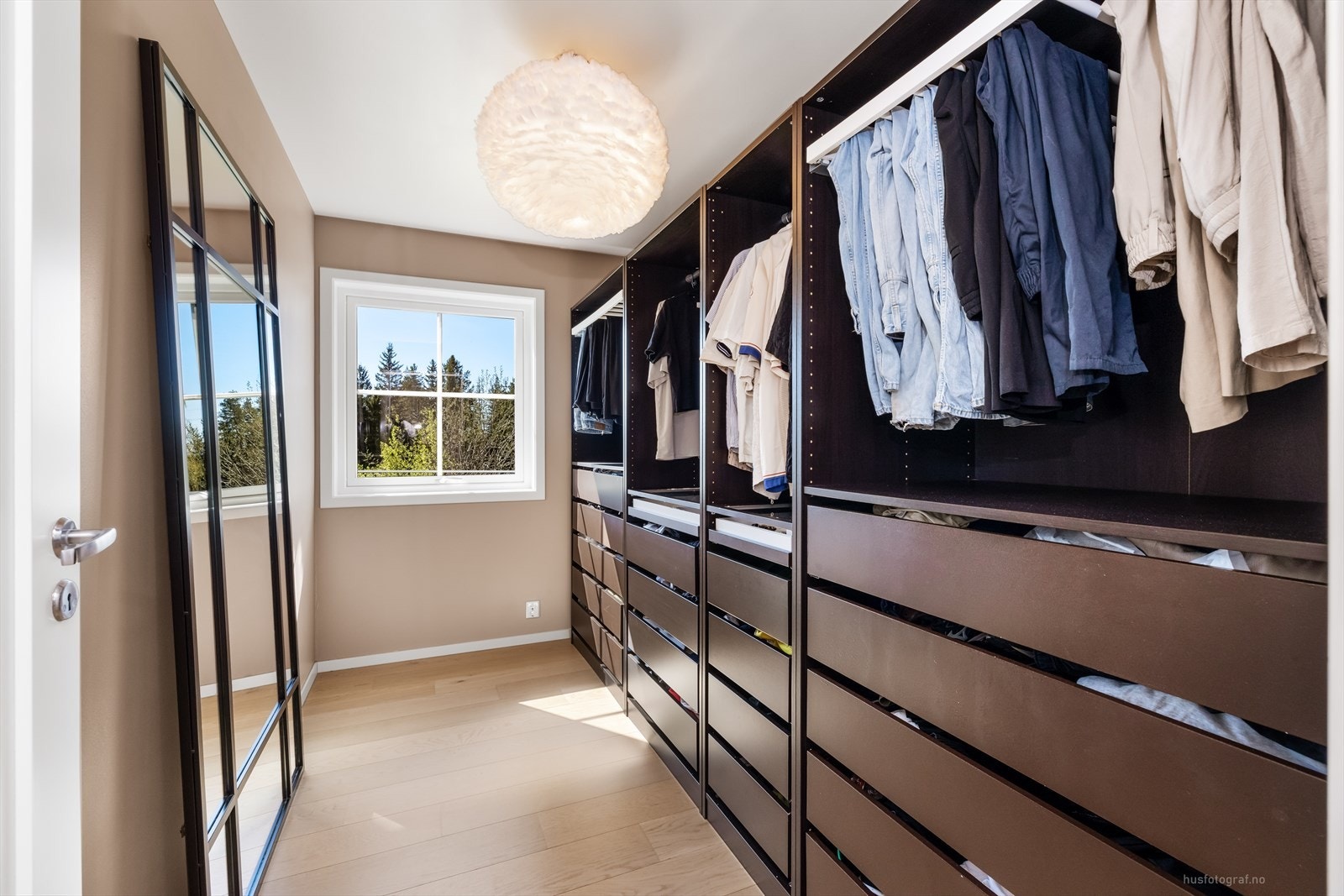 Ett av rommene i underetasjen er innredet som en praktisk garderobe med rikelig oppbevaringsplass. Galleribilde