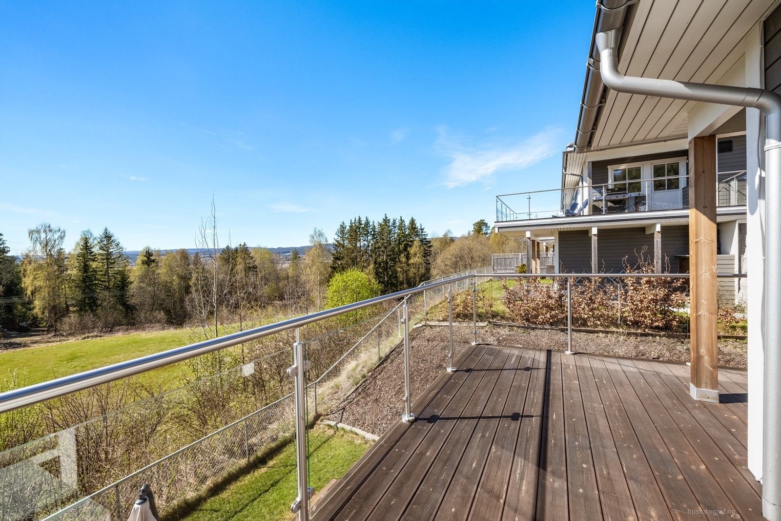 Terrassen i første etasje er på ca. 20 m² og har et stilrent rekkverk i glass og aluminium. Galleribilde