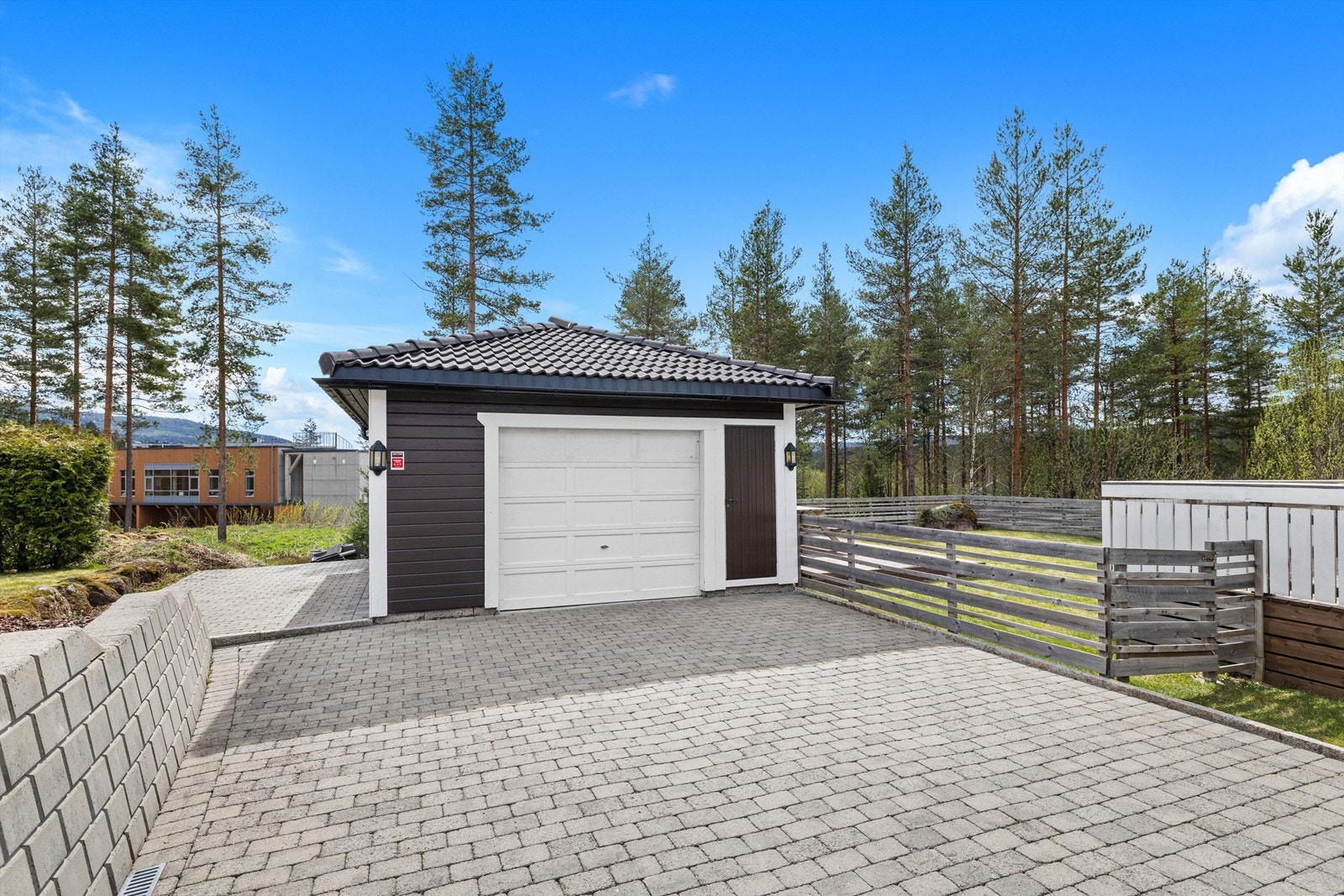 Eiet tomt opparbeidet med belegningsstein, terrasse på terreng, biloppstillingsplass, plenarealer, diverse beplantninger. Frittstående garasje. Galleribilde
