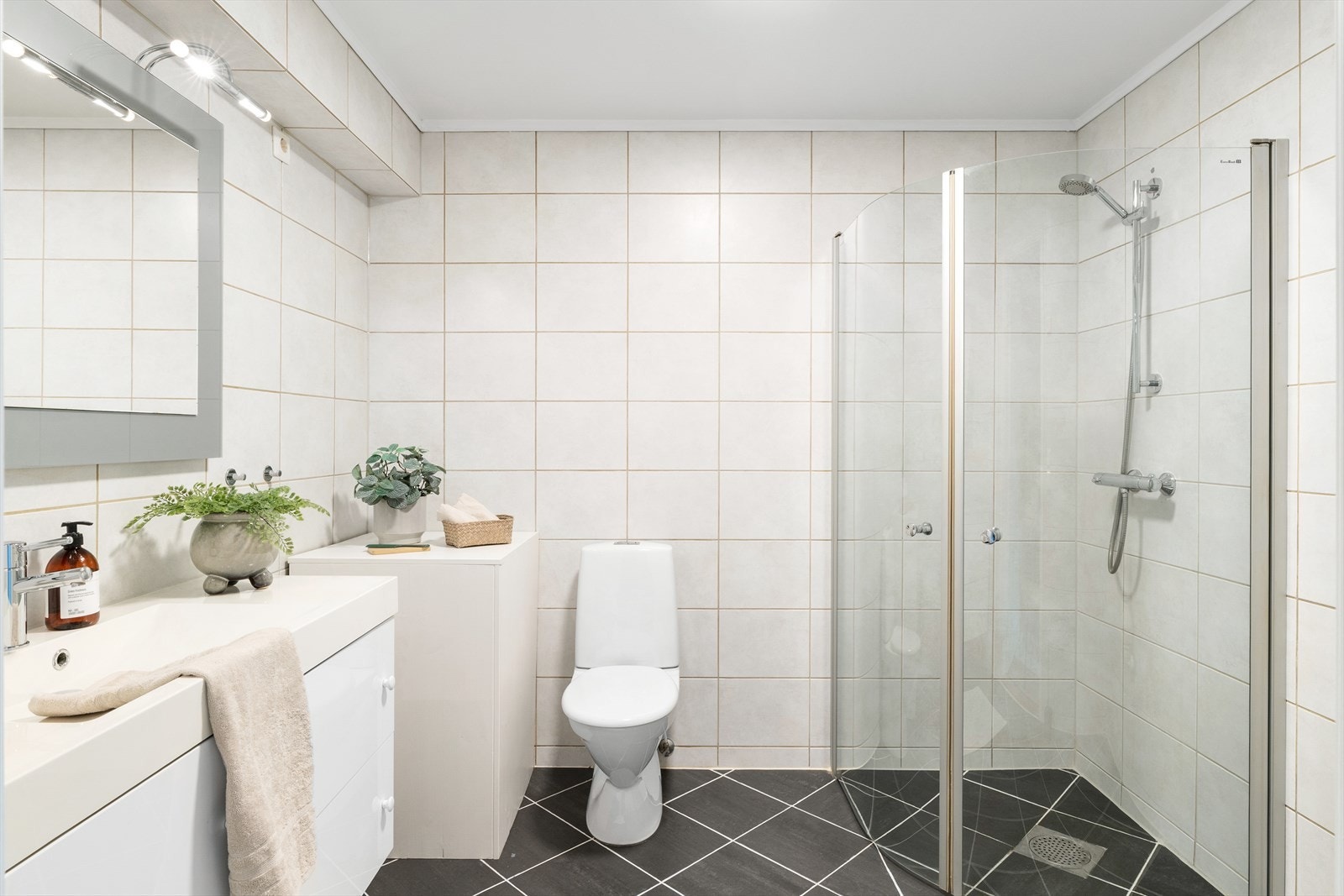 Helfliset bad med wc, dusjhjørne, vask i seksjon og varme i gulv for ekstra komfort. Galleribilde