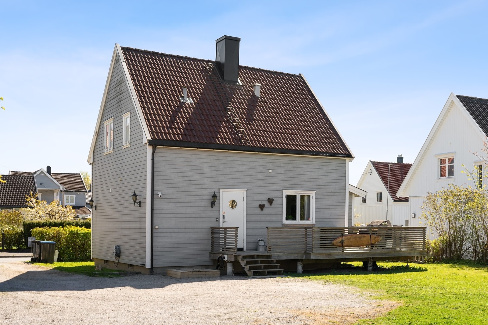 Stor og solrik tomt med grus i innkjørsel og på gårdsplassen. Galleribilde