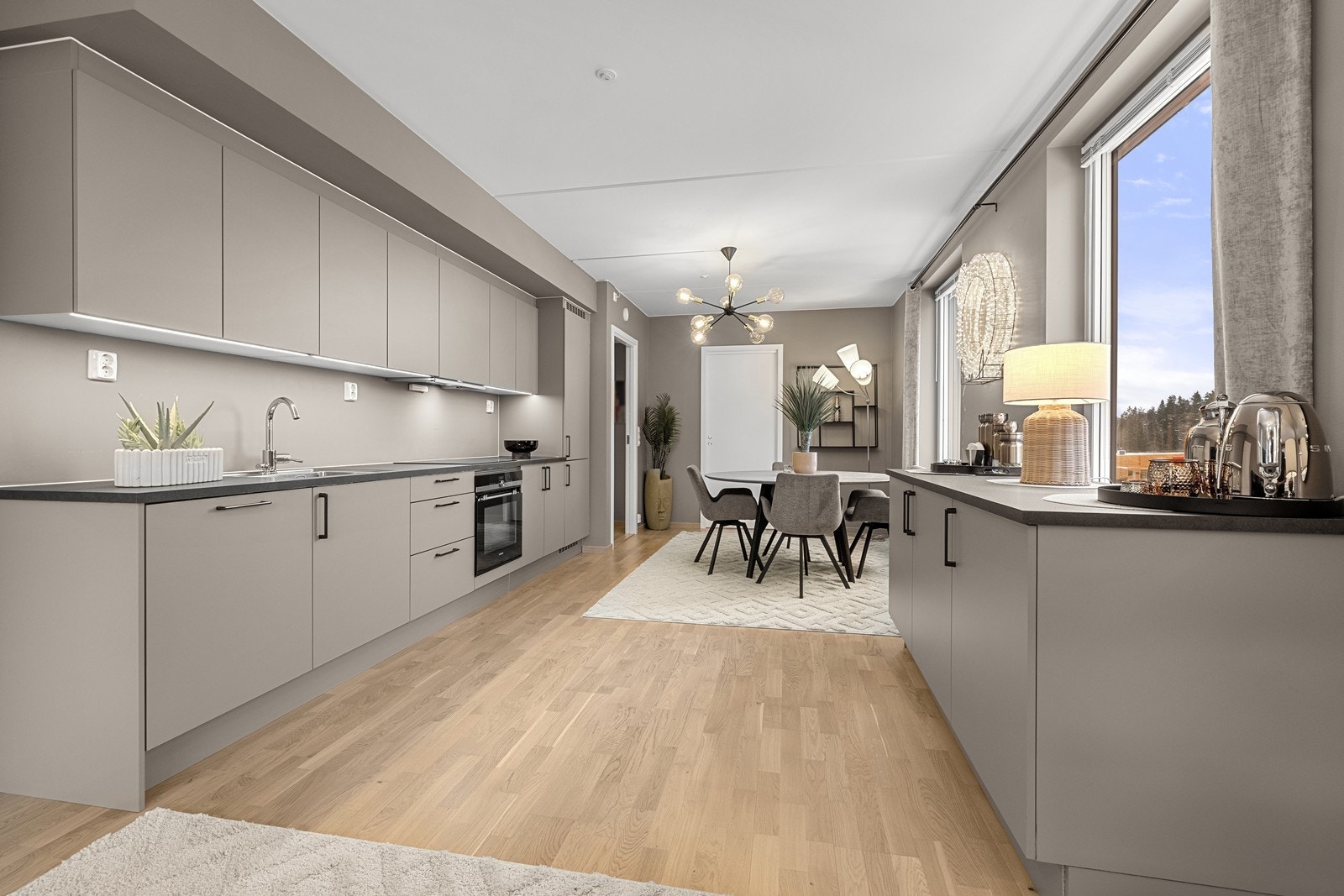 Kjøkkenet har en moderne HTH-innredning med slette, lakkerte fronter og laminat benkeplate. Galleribilde
