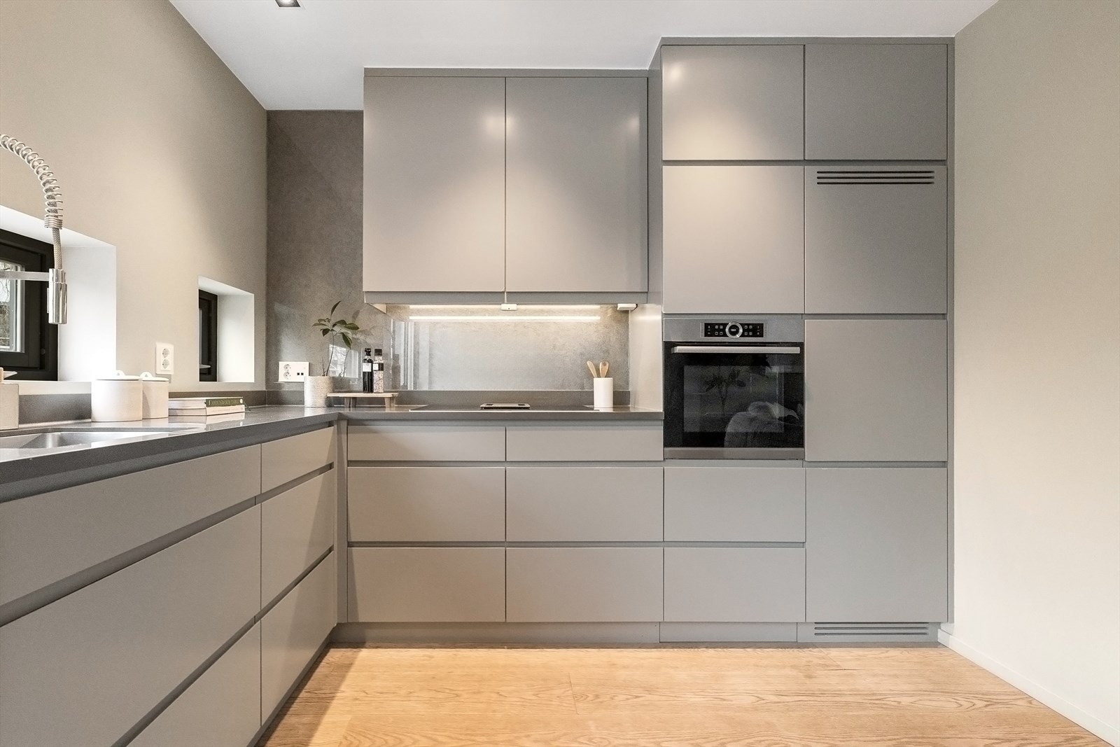 Spesialdesignet kjøkken i den elegante fargen Mohair, med brede skuffer og benkeplater i Corian. Galleribilde