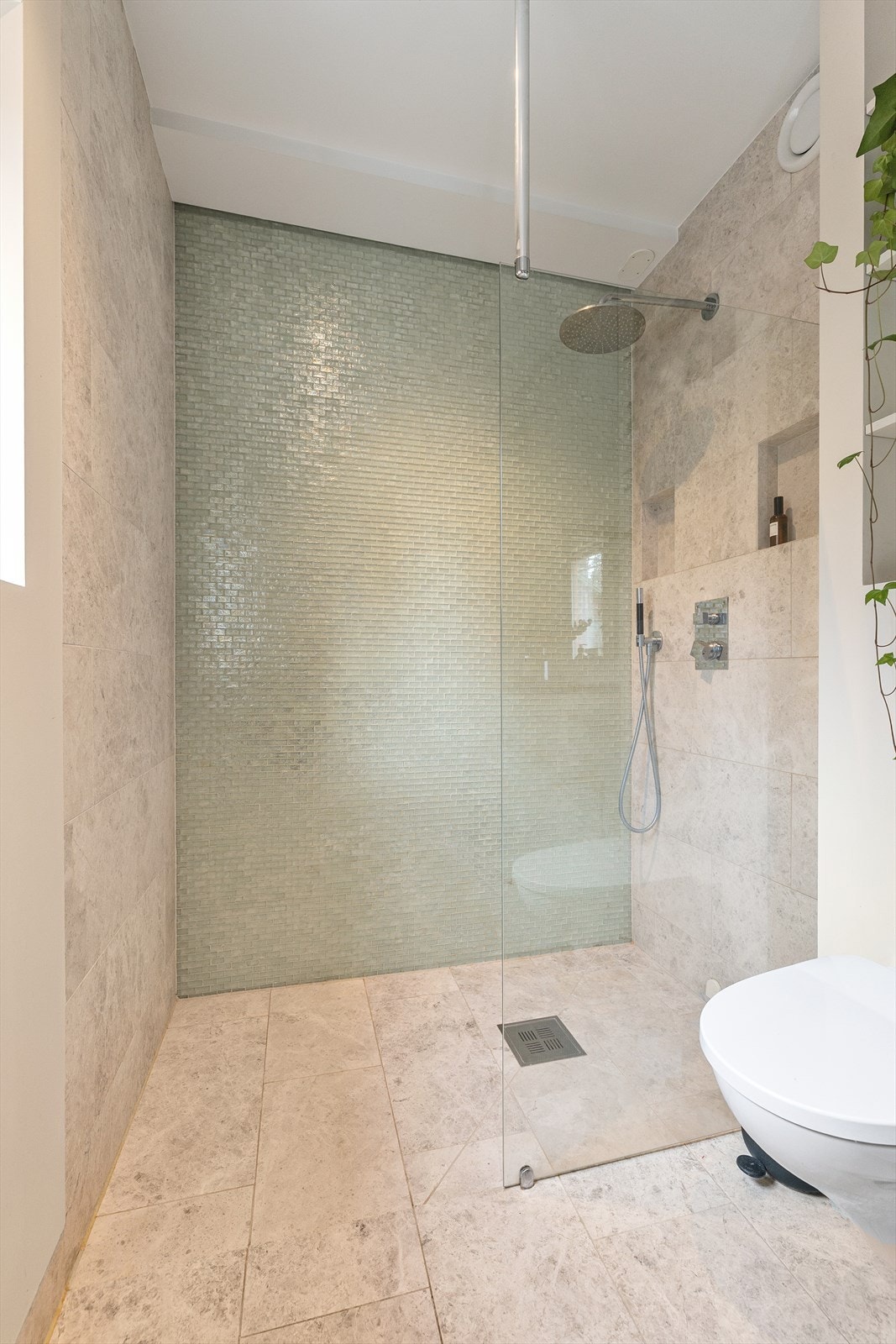 Utstyrt med "waterfall"-dusj og armaturer fra Vola. Dobbel servant med 30 mm Silestone benkeplate og underlimte servanter. Vegghengt toalett, dusjhjørne og balansert ventilasjon. Galleribilde