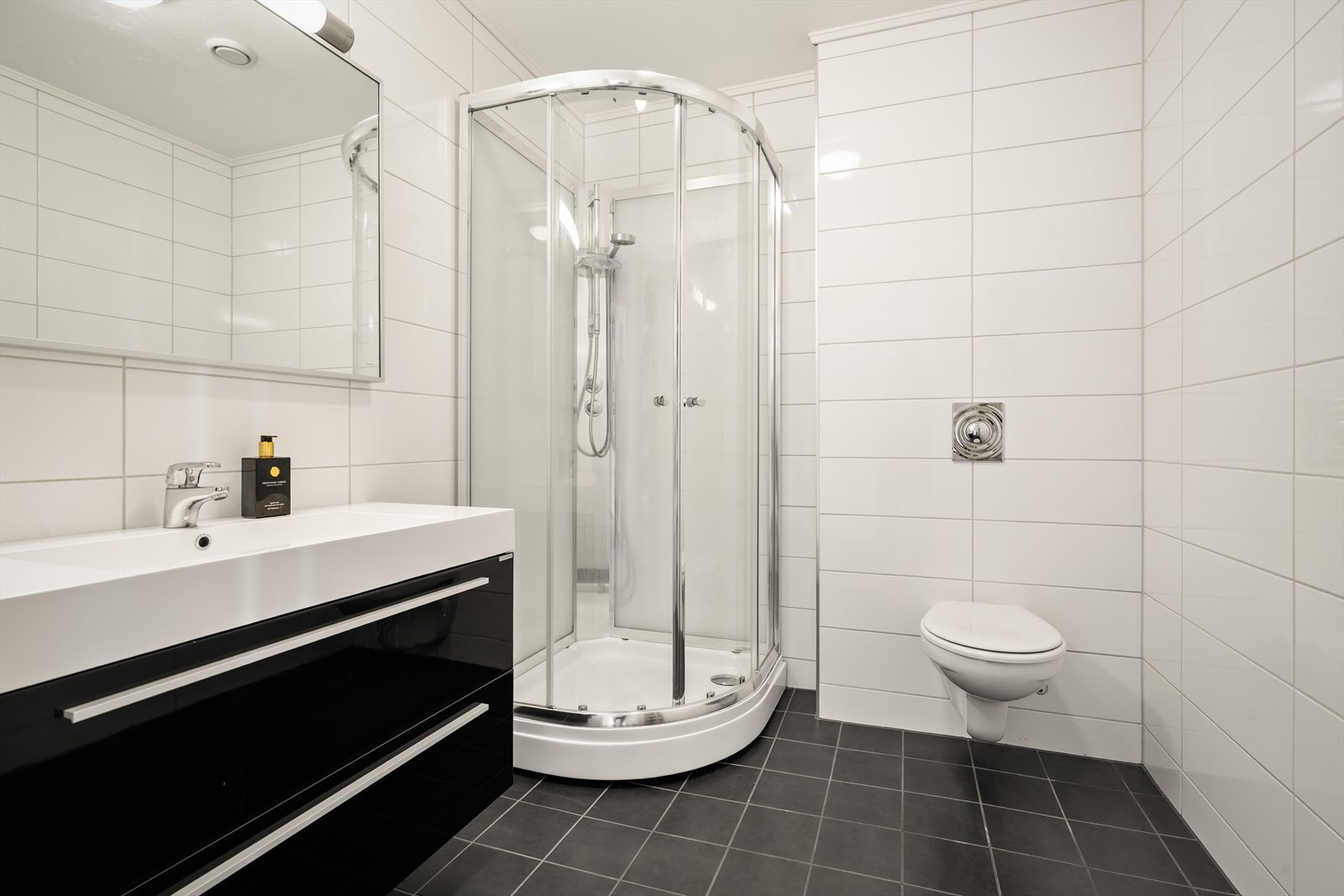 Badet i første etasje er utstyrt med dusjkabinett, veggmontert toalett og servantinnredning. Galleribilde