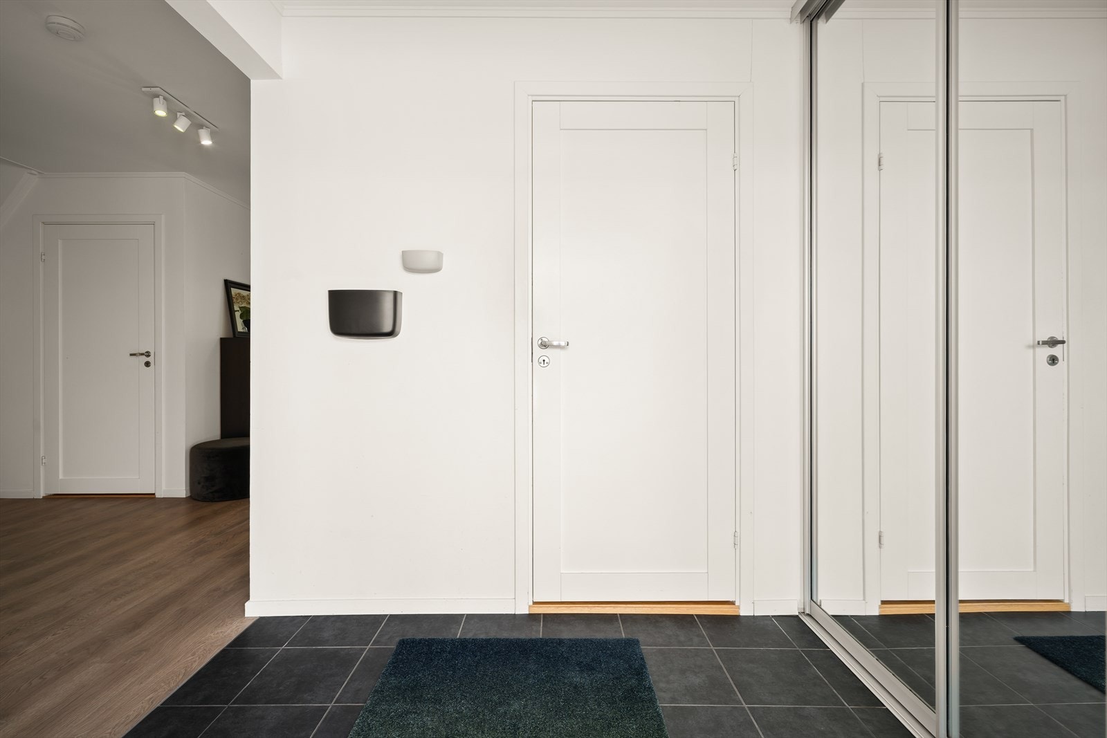 Entreén har flislagt gulv med varmekabler og god plass til oppbevaring av yttertøy i skyvedørsgarderobe med speil. Galleribilde