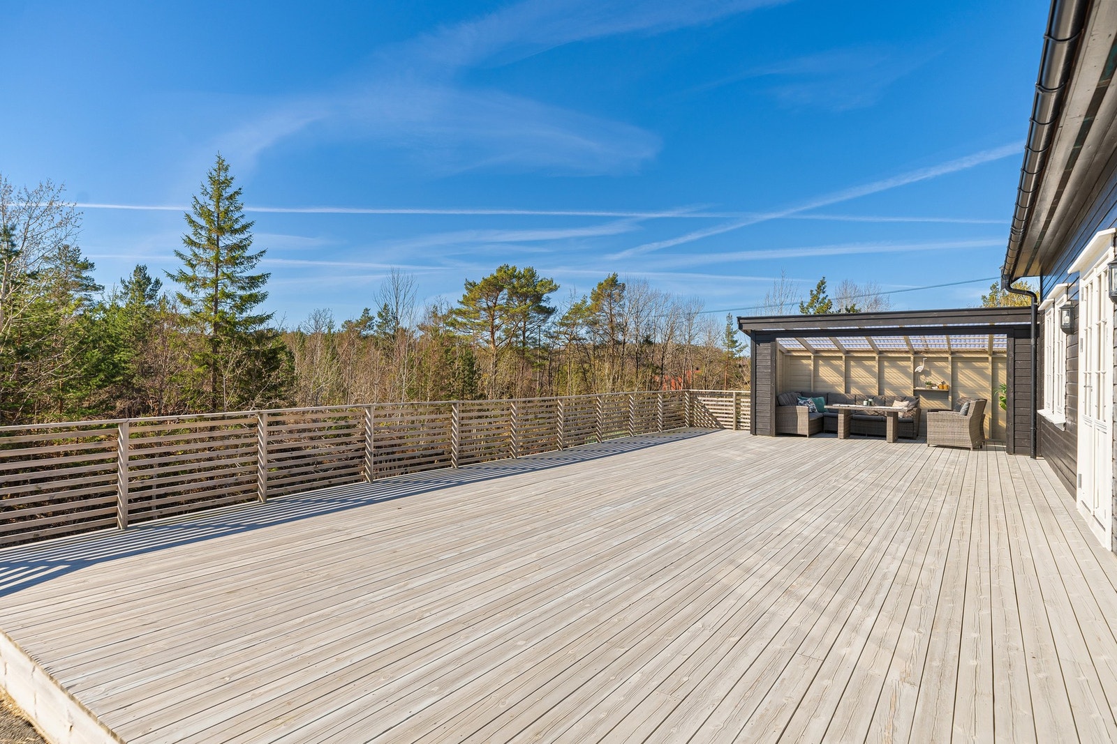 Stor og solrik terrasse på med tilhørende utestue som gir en lun og skjermet uteplass. Galleribilde