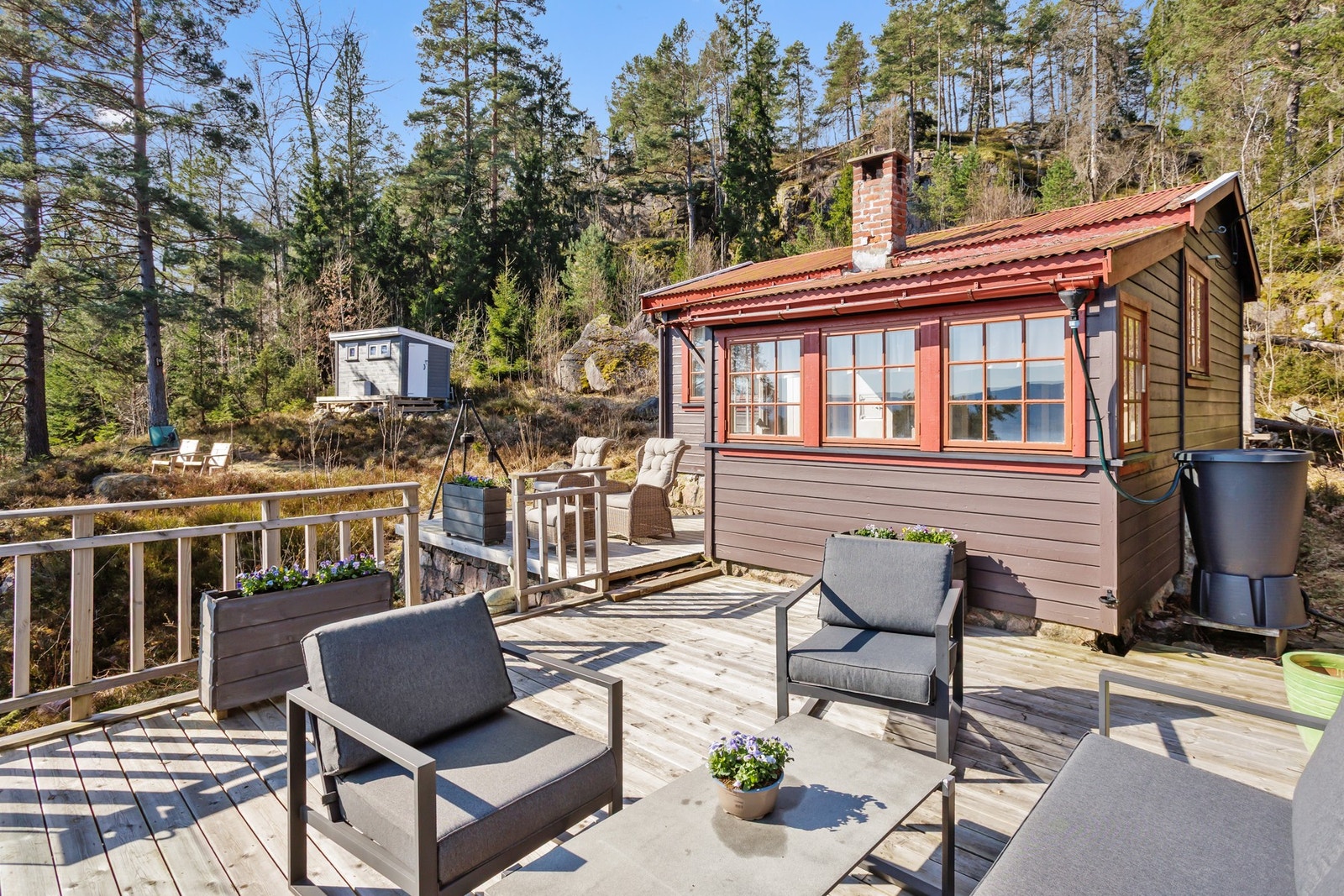Terrassen har gulv av terrassebord og rekkverk i tre og glassfelt Galleribilde
