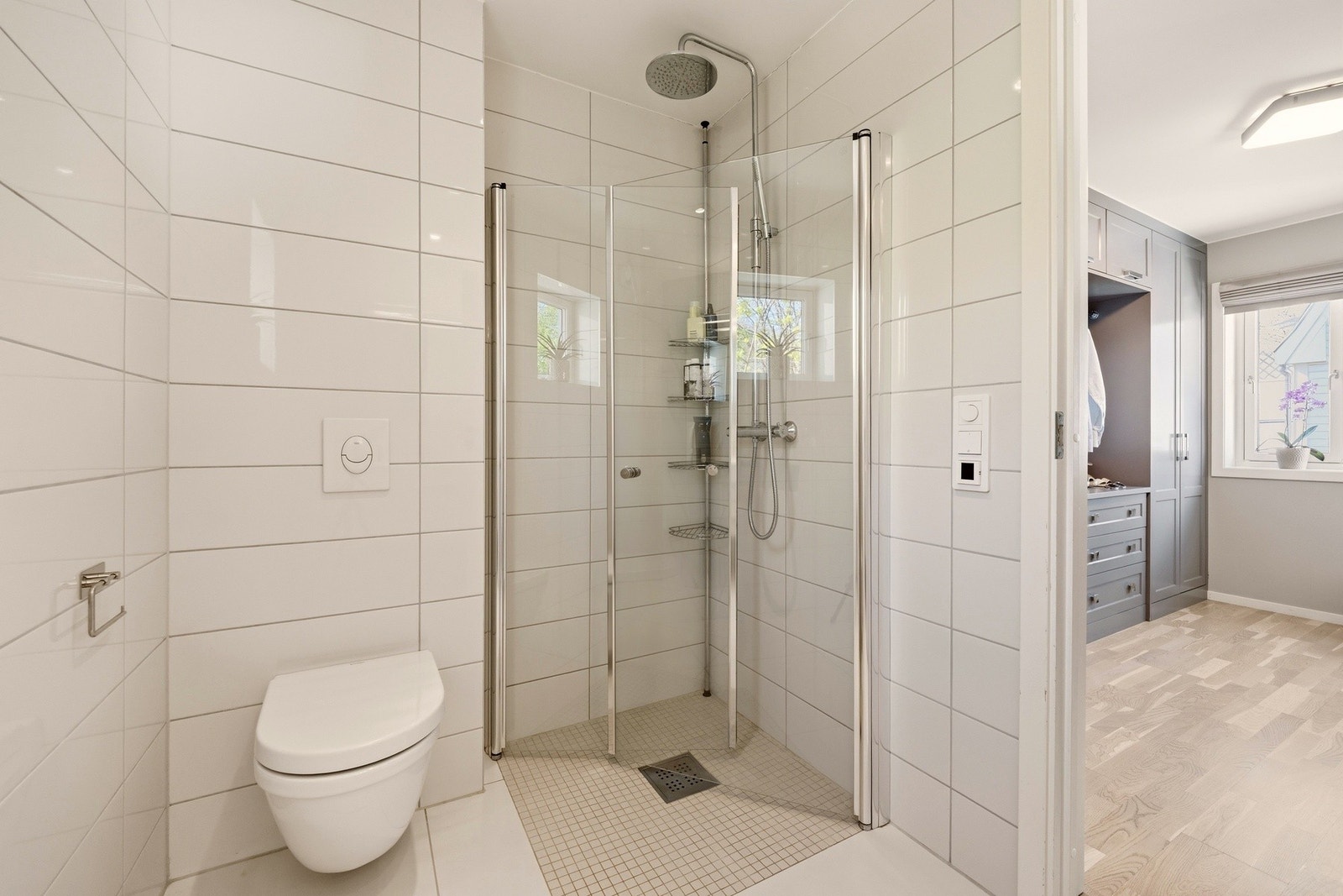 Badet fremstår som lyst og moderne, med flislagte overflater og en praktisk utforming. Galleribilde