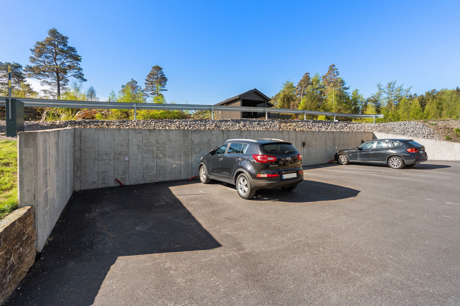 Praktisk biloppstillingsplass på asfaltert felles parkeringsområde, tilrettelagt for montering av elbillader. Galleribilde