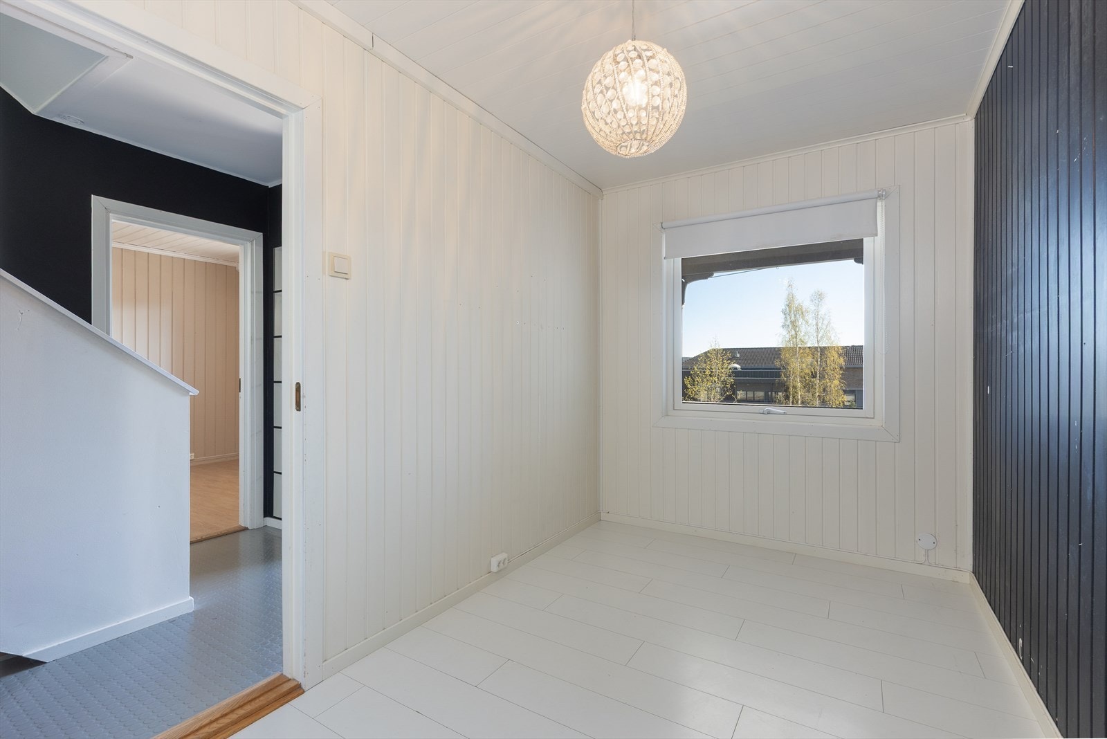 Det ene av to soverom i underetasjen. Rommet har malte panelplater på veggene. Galleribilde