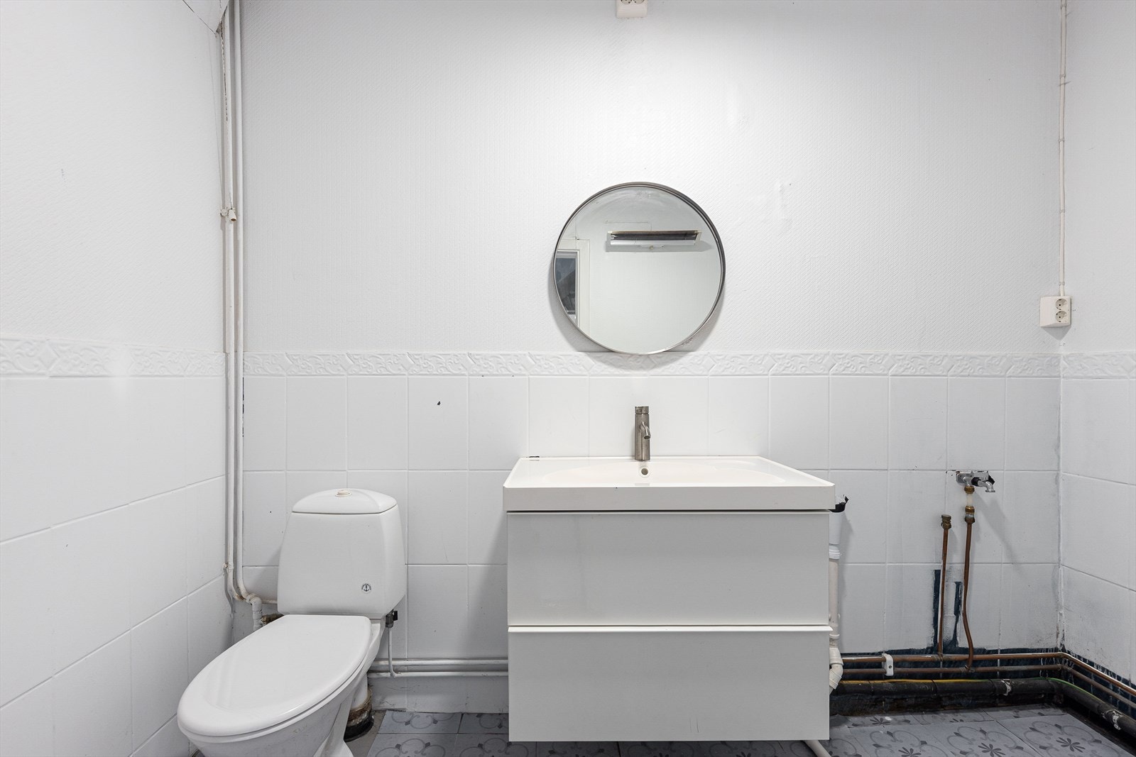 Praktisk vaskerom i underetasjen, utstyrt med toalett og opplegg for vaskemaskin. Galleribilde