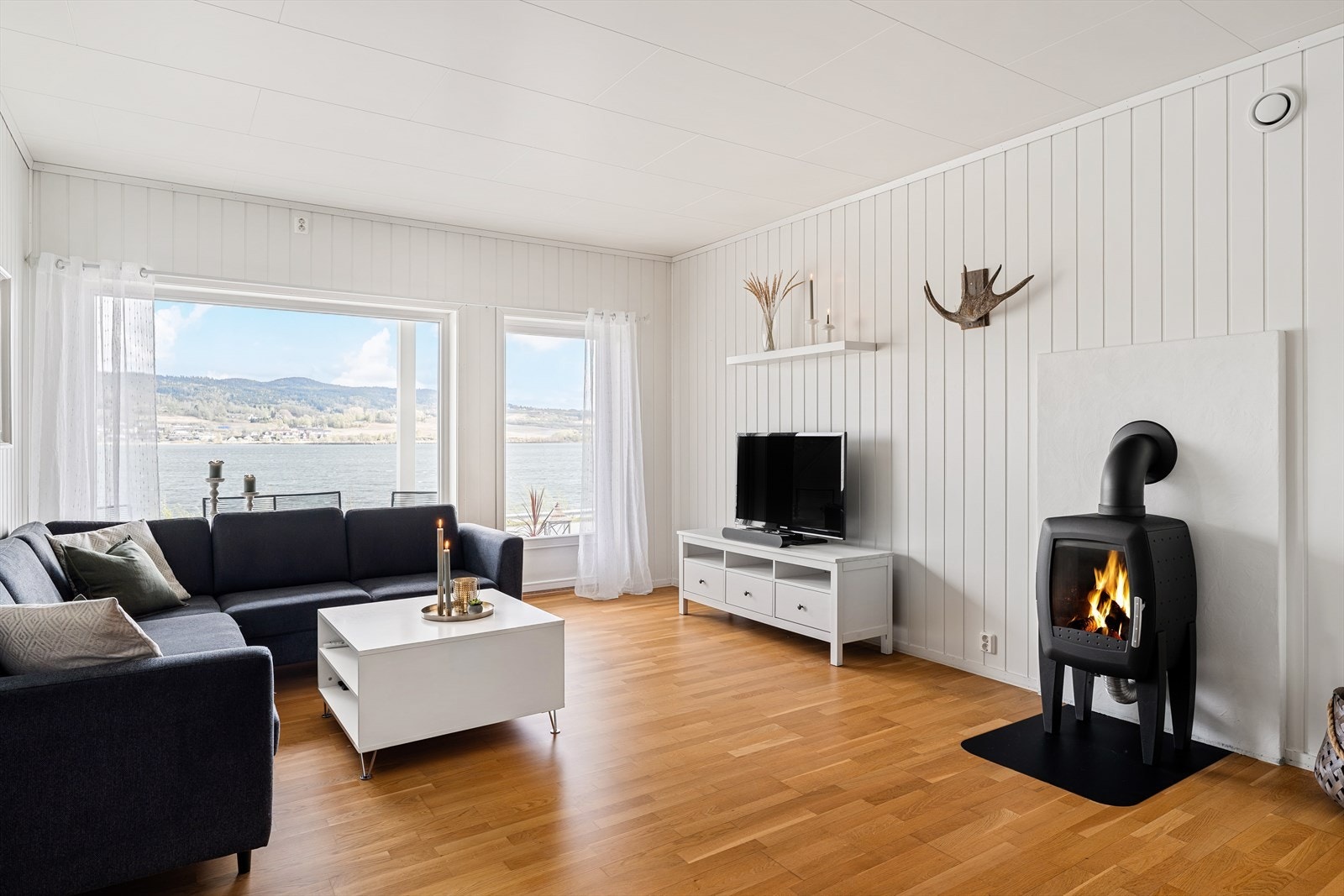 Lys og romslig stue med panoramautsikt mot sjøen. Galleribilde