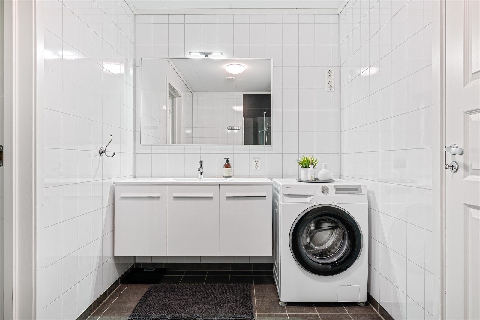 Badet er velutstyrt med servant, speil, dusj med innfellbare glassdører, WC og opplegg for vaskemaskin. Galleribilde