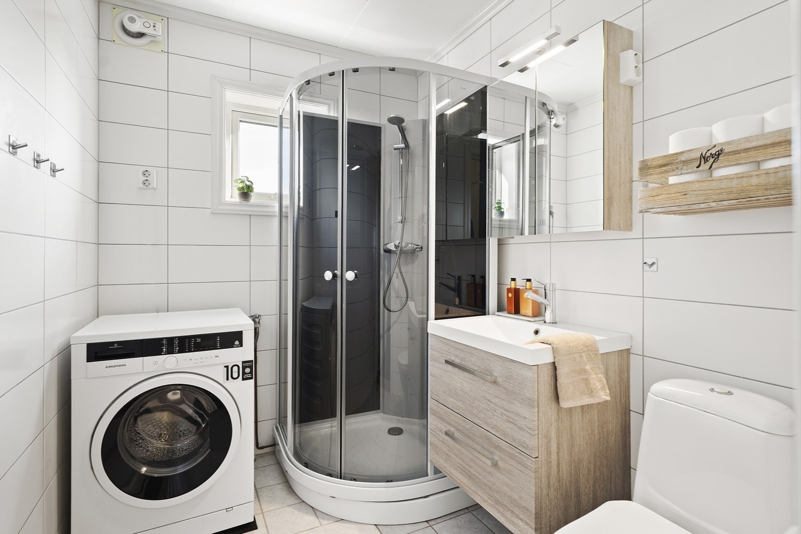 Badet er lyst og flislagt på vegger og gulv. Galleribilde