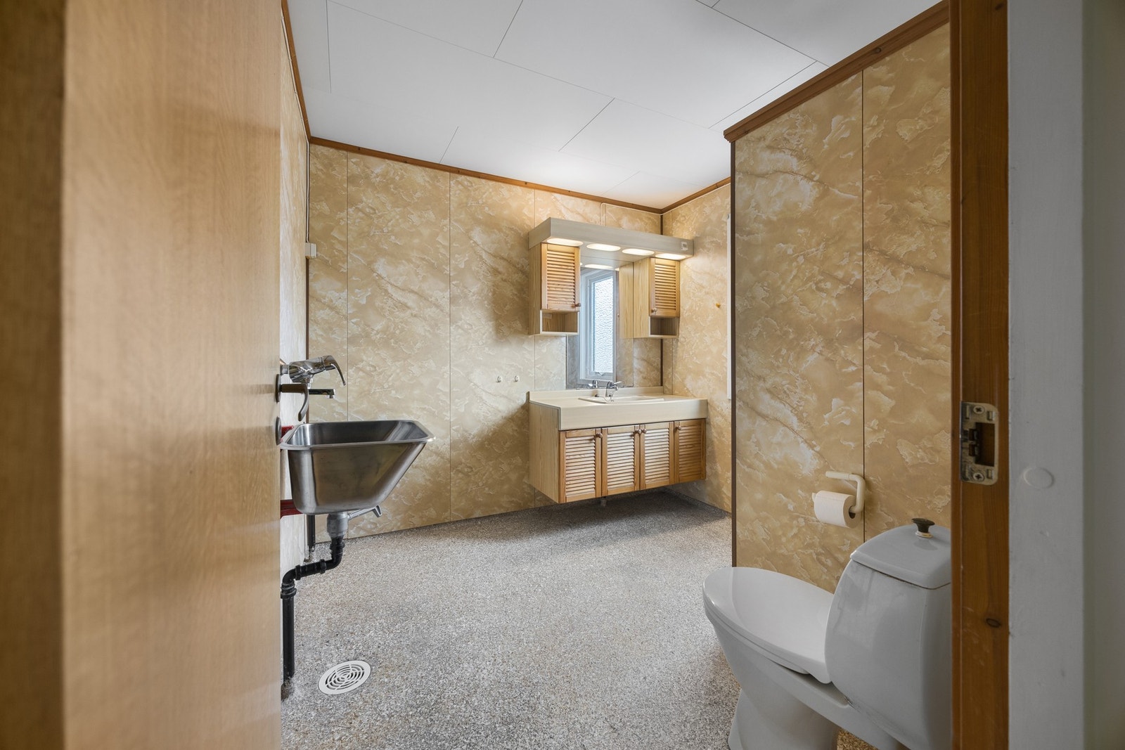 Badet er utstyrt med servantskap, toalett, utslagsvask og dusjnisje Galleribilde