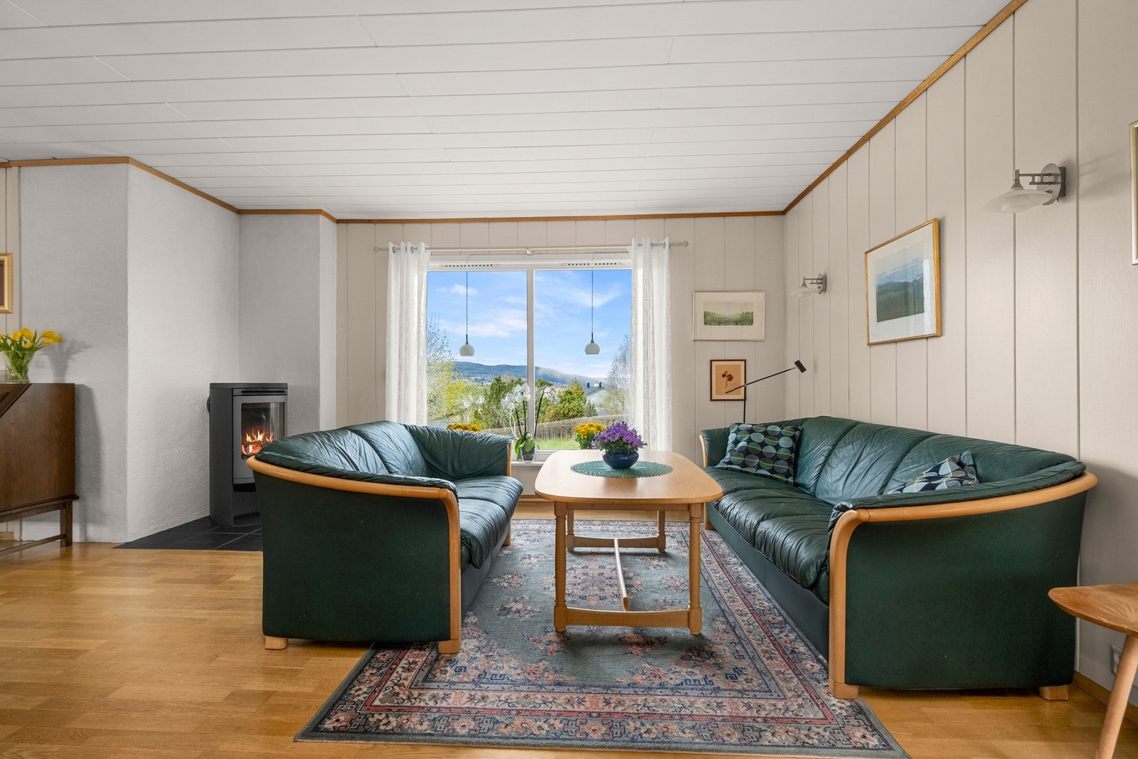 Stor og lys stue med store vindusflater og gjennomlys som slipper det fine lyset inn. Galleribilde
