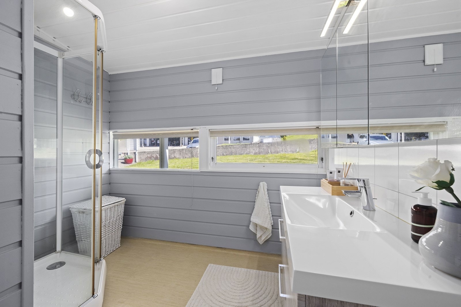Badet er utstyrt med dusjkabinett, baderomsinnredning med servant og har våtromsbelegg på gulv. Galleribilde