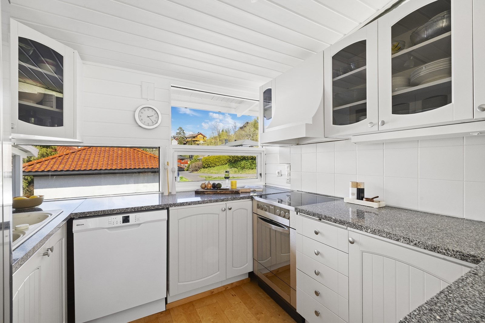 Kjøkkenet er praktisk innrettet med en profilert hvit innredning og benkeplate i stein. Det er godt med skap- og benkeplass. Kjøkkenet er utstyrt med ventilator og har fliser over benken for enkelt vedlikehold. Galleribilde