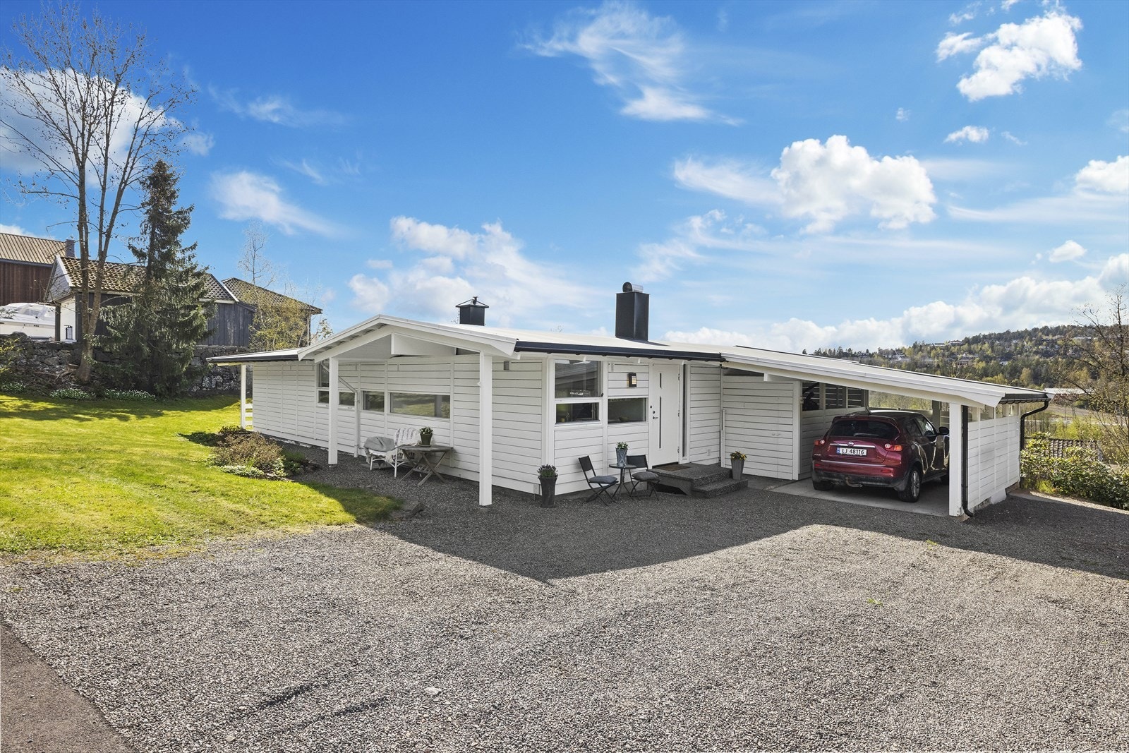 Det er utmerkede parkeringsmuligheter på eiendommen. Boligen har en praktisk carport på ca. 15 m² som gir skjermet parkering for én bil. I tillegg er det en stor, gruslagt innkjørsel med god plass til flere biler. Galleribilde