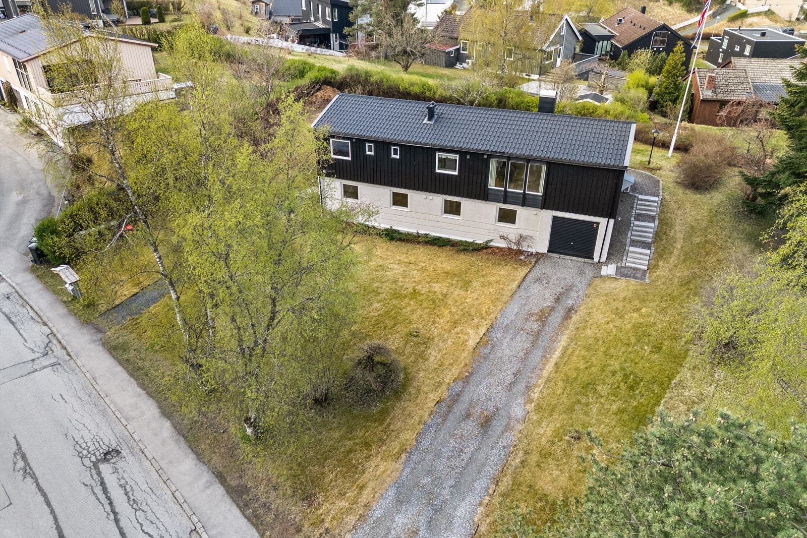 Stor gårdsplass med plass til flere biler og innkjøring til garasje. Galleribilde