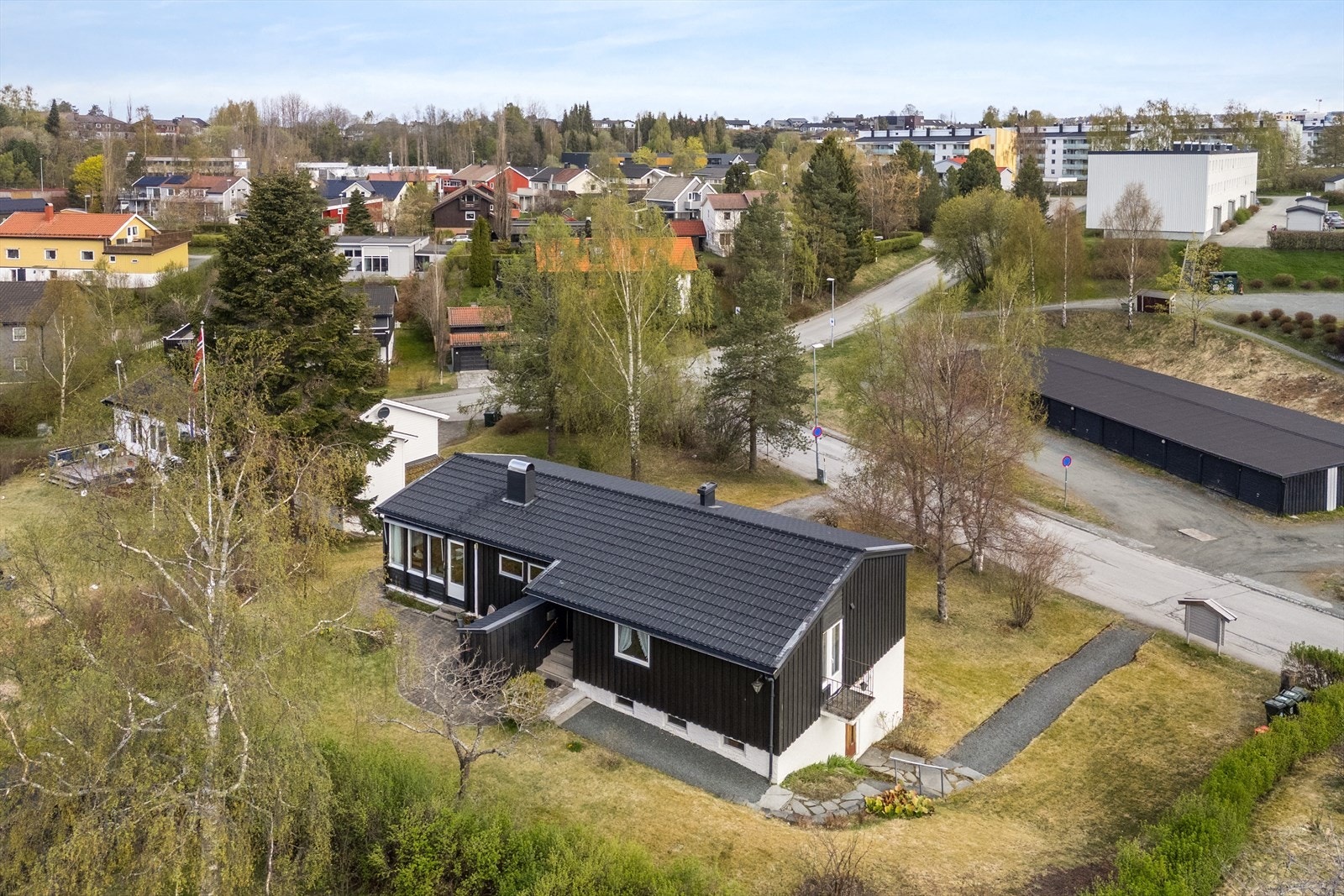 Uteområdet er pent opparbeidet med steinbelagt terrasse, plen og variert beplantning. Galleribilde